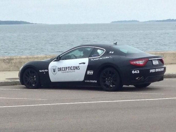 A Maserati resembling a police cruiser sits parked along the shore in Quincy, Mass