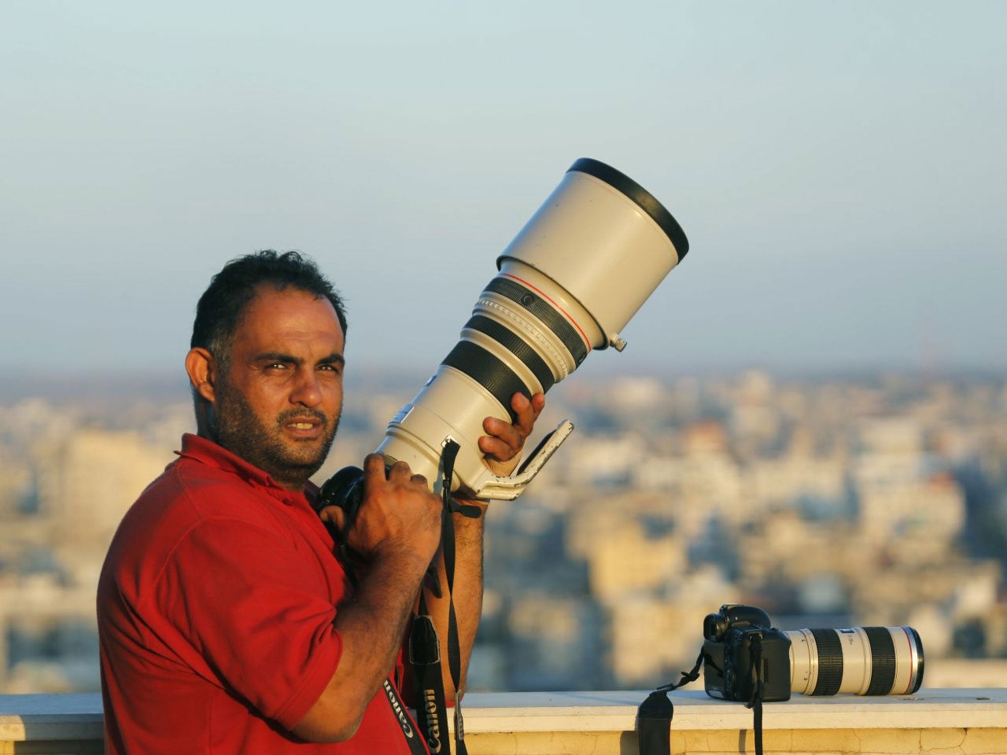 Associated Press photographer Hatem Moussa holds his camera, in Gaza City (AP)