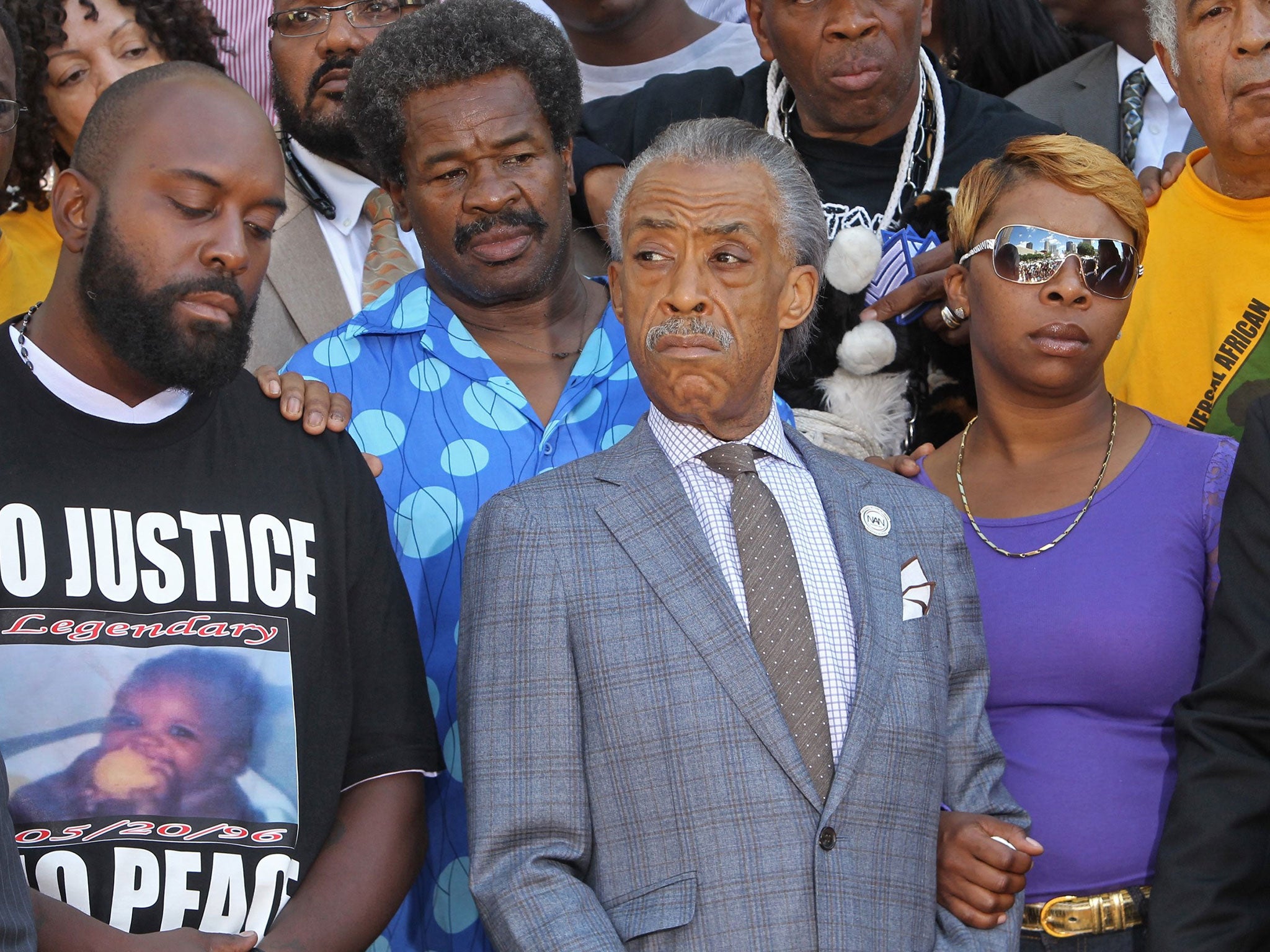 Michael Brown’s parents, Michael Brown Sr, left, and Lesley McSpadden, right, stand next to the Rev Al Sharpton in St Louis on Tuesday