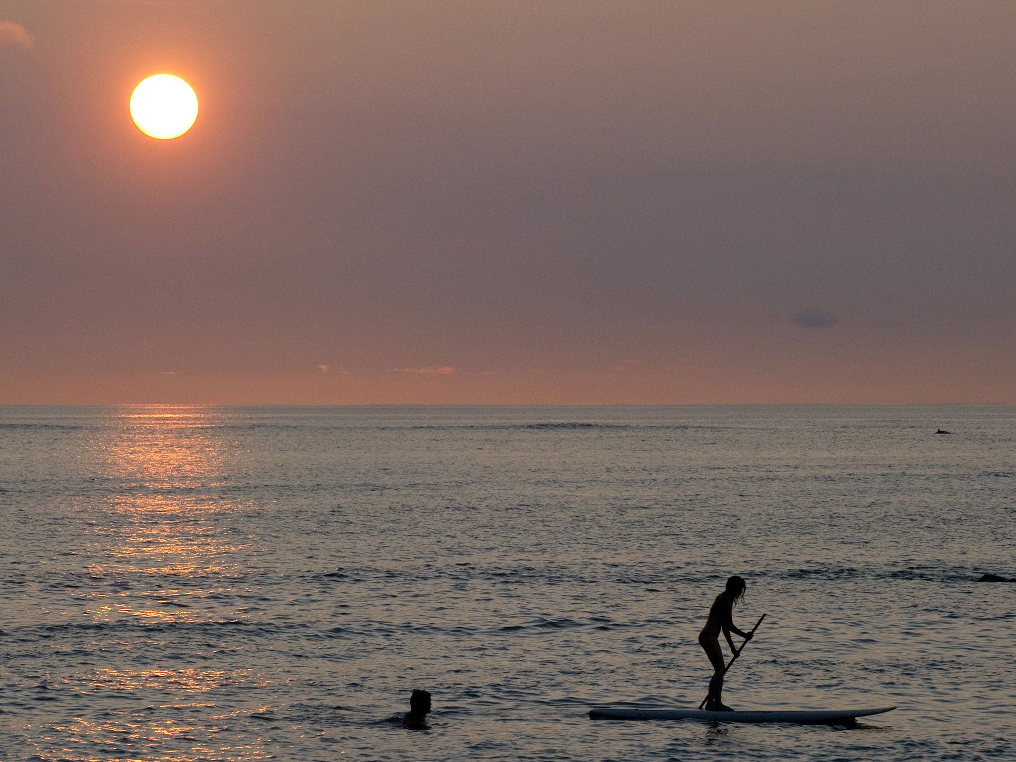 The woman wanted to enjoy the evening on the sea on an old paddle board