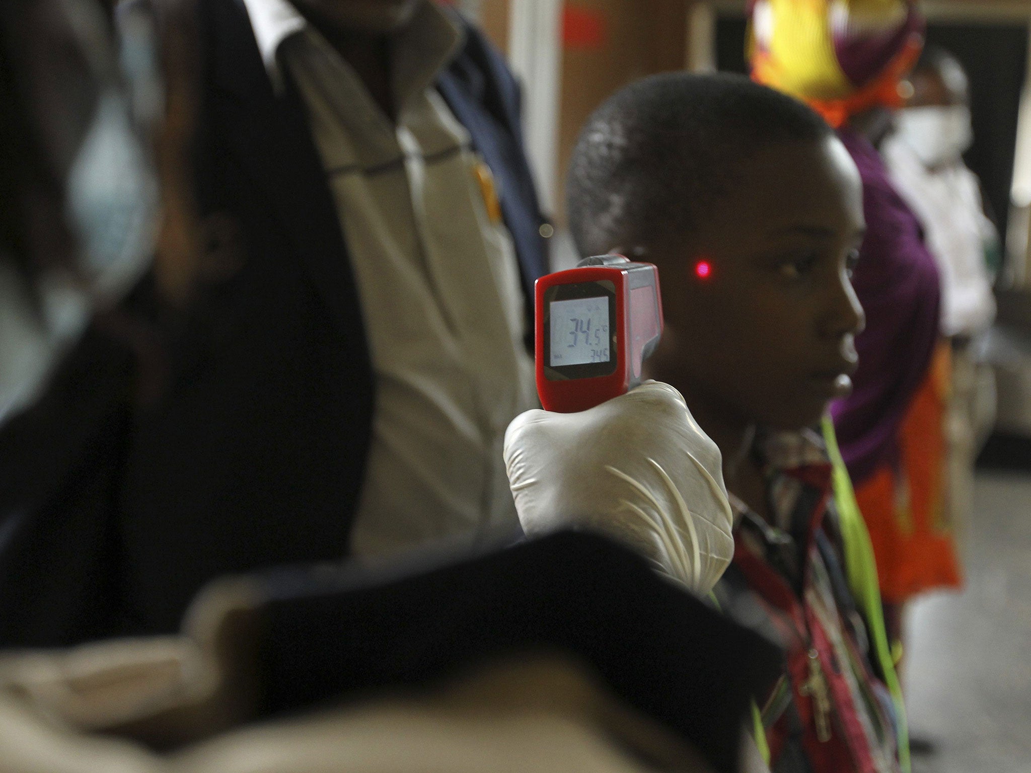 A boy’s temperature is taken using an infrared laser thermometer at the international airport in Abuja, Nigeria