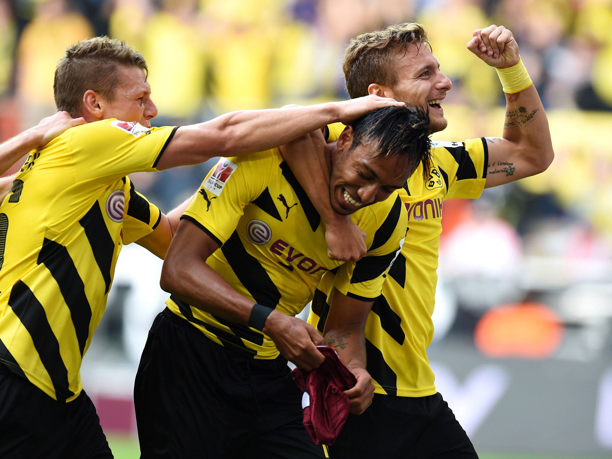 Dortmund players swamp Aubameyang as he attempts to put on his mask