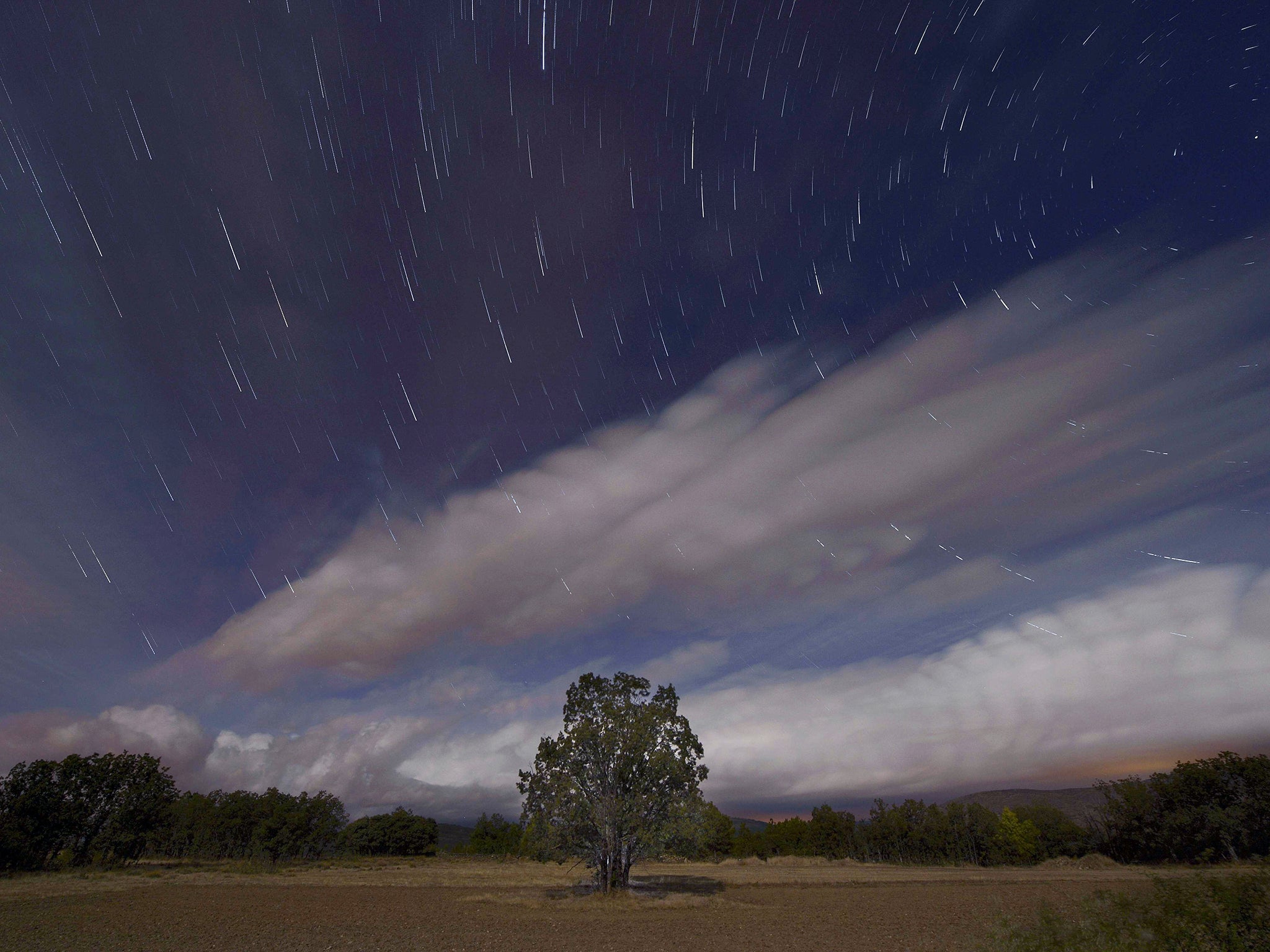 A Perseids meteor shower in the night sky from the mountains of the Sierra Norte de Madrid near the municipality of Valle del Lozoya