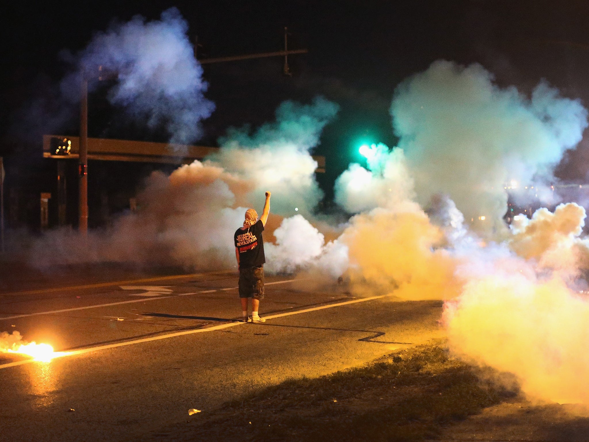 A demonstrator stands his ground as police fire tear gas