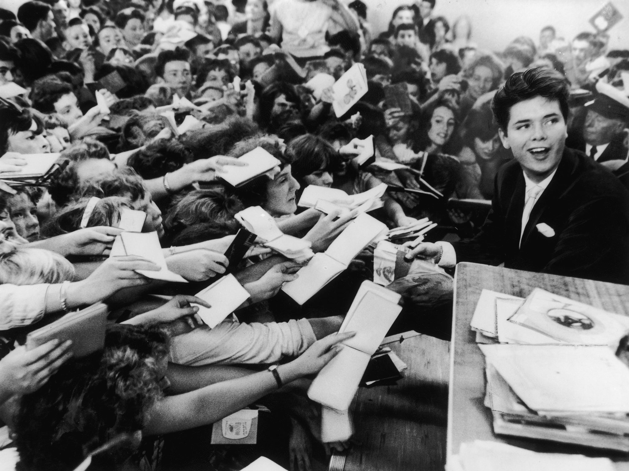 18 year-old Cliff Richard is mobbed by fans at the Hulton Boys and Girls Exhibition at Olympia's Disc Theatre on 19 August 1959