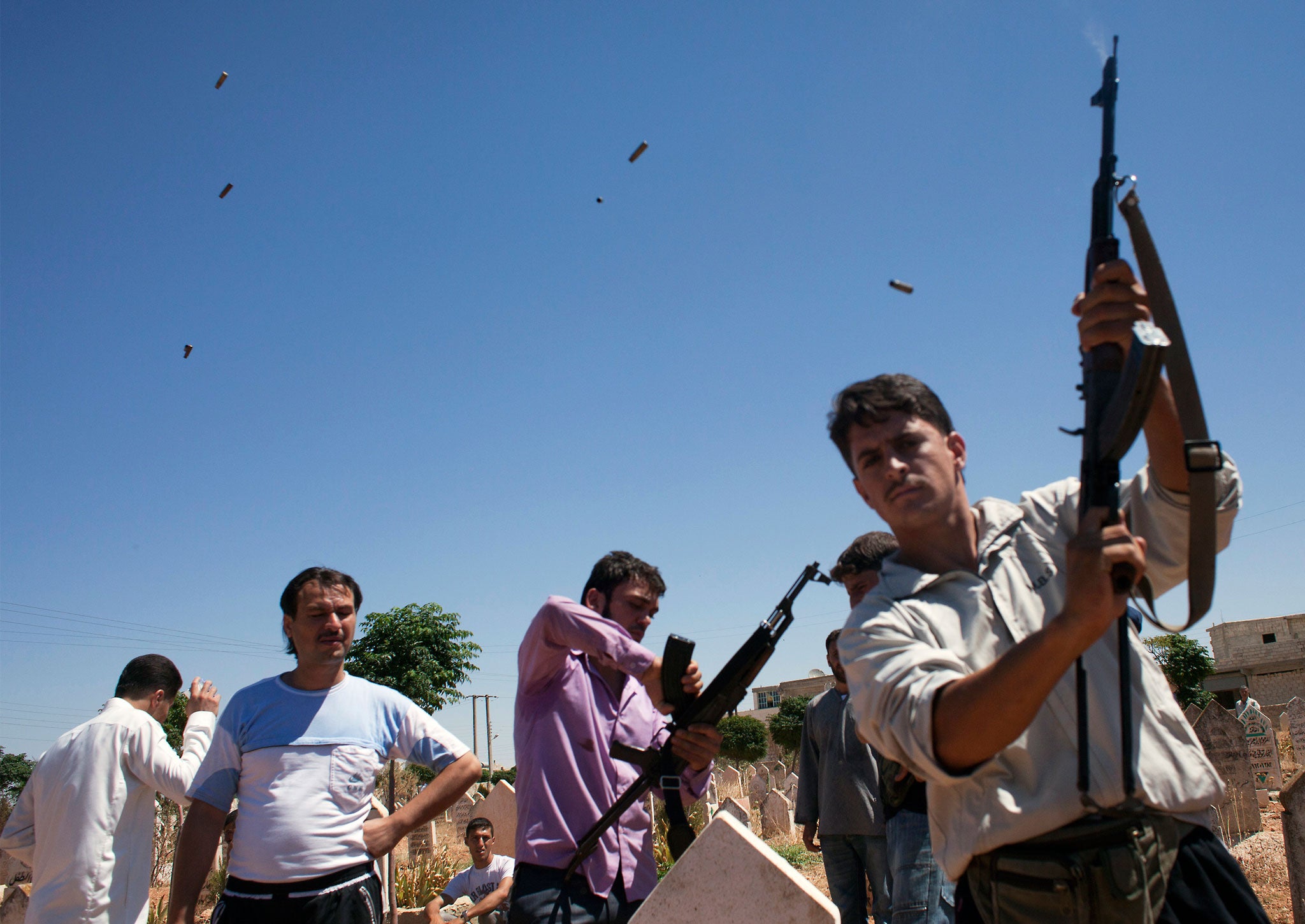 A fighter from the Free Syrian Army fires rounds into the air on August 21, 2012, during the funeral of 17-year old Ahmed Hamoudi