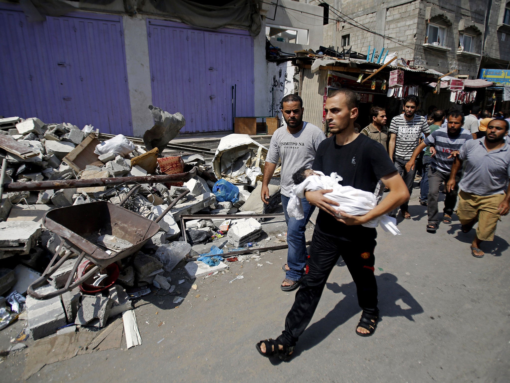 The most vulnerable victims: A relative carries the body of 4 month-old Asma al-Bakri during her funeral in Gaza City. More than 1,900 people have been killed so far in the conflict, 452 of them children