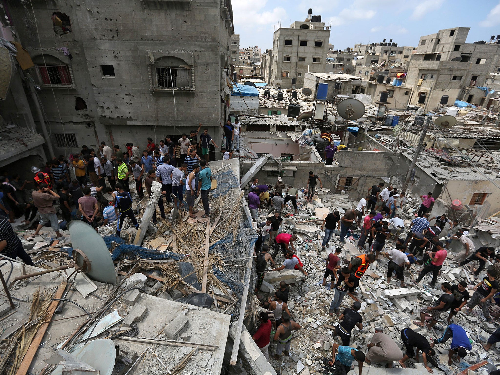 Palestinians inspect the rubble of the destroyed house