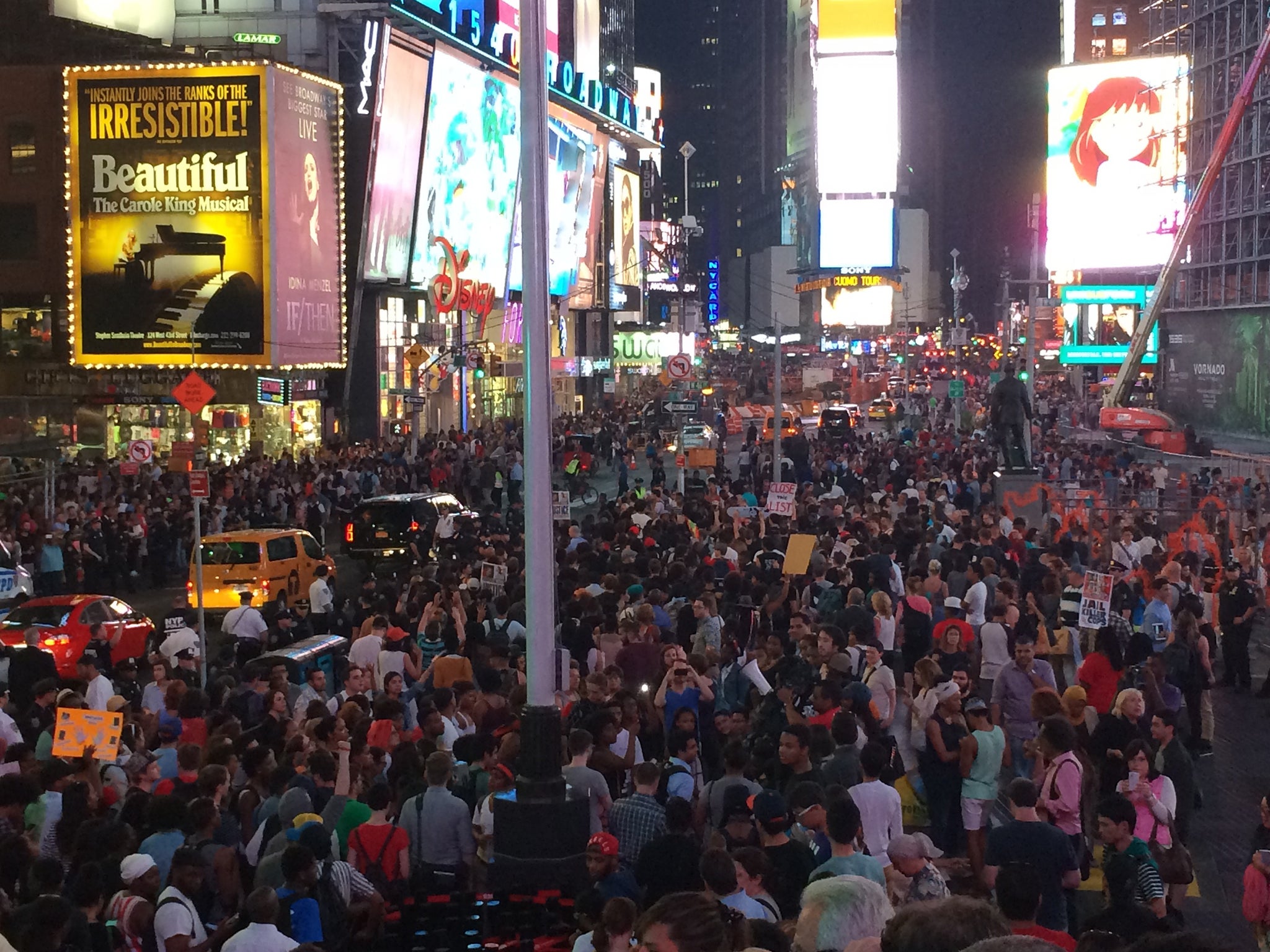 Thousands of people peacefully gathered in Manhattan's Times Square and Union Square, invoking the rallying cries "hands up, don't shoot" and "I can't breathe," alluding to the deaths of Michael Brown in Ferguson