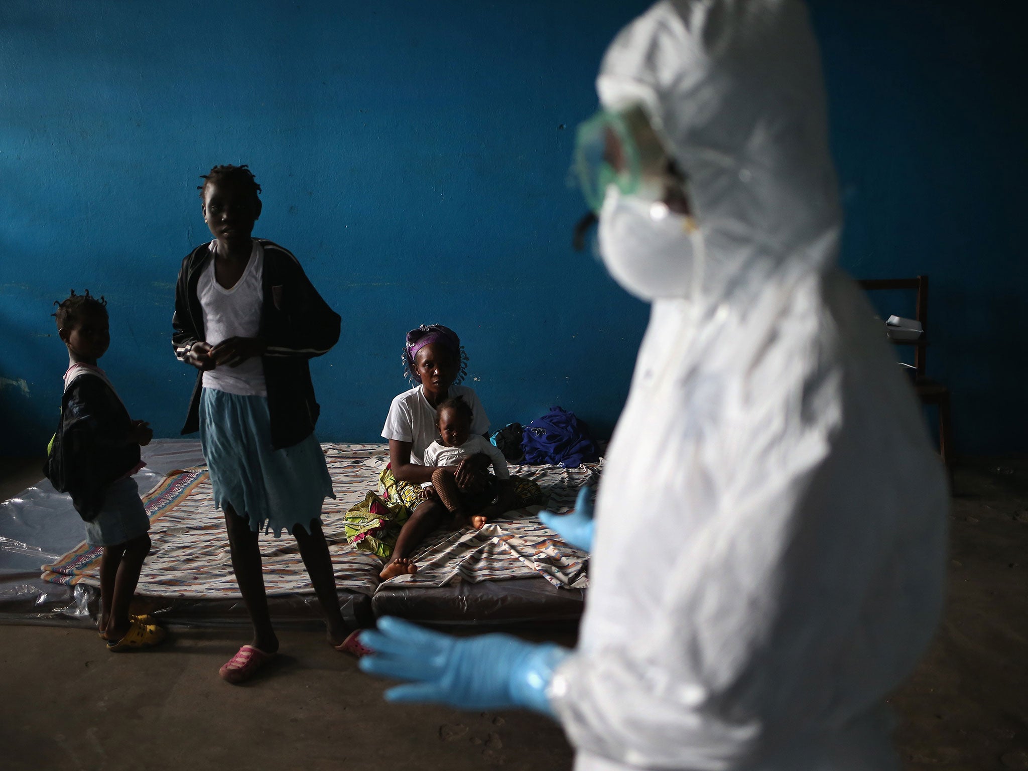 A Liberian health worker speaks with families in a classroom now used as an Ebola isolation
ward in Monrovia, Liberia