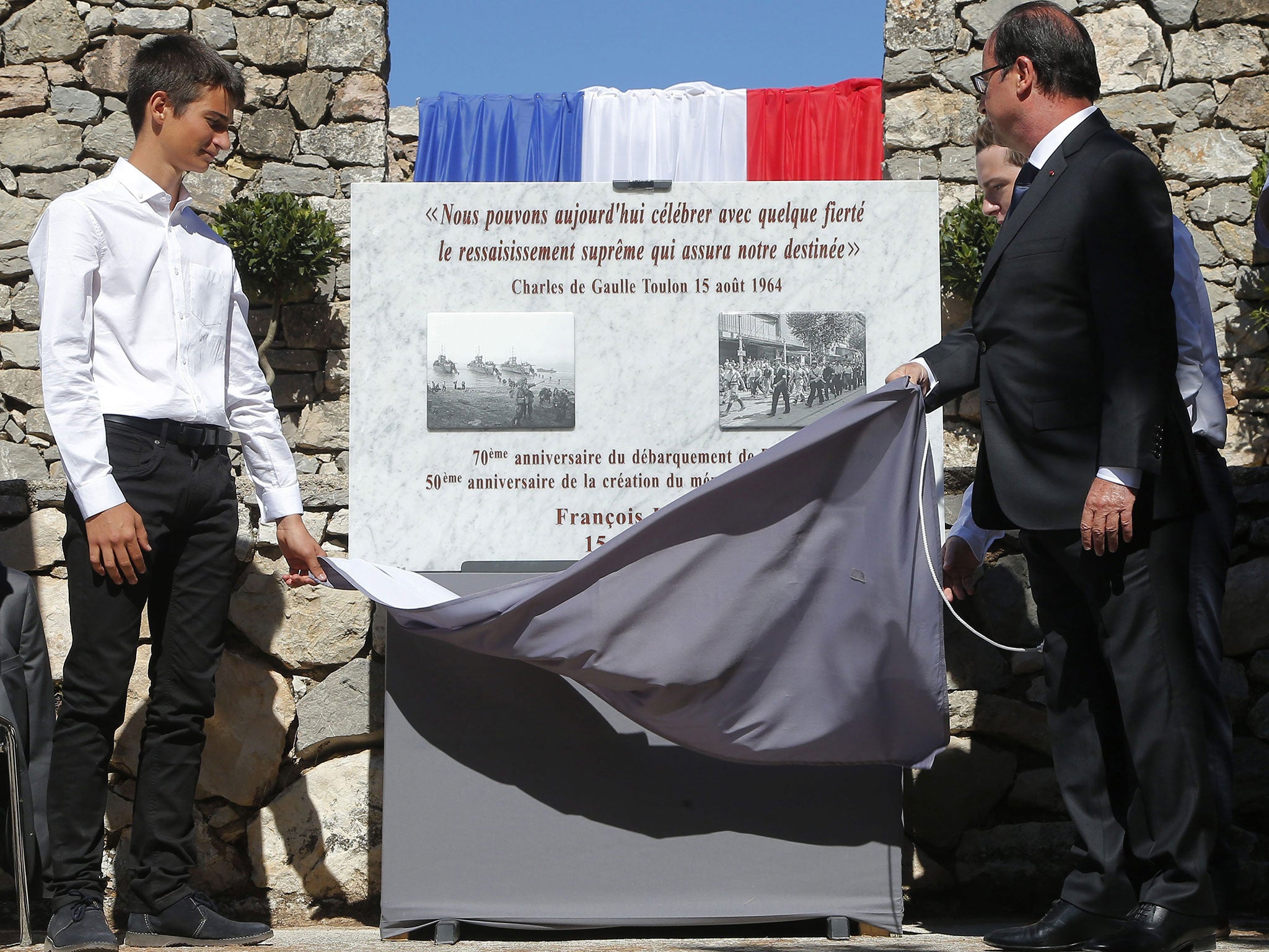 French President Francois Hollande (R) unveils a memorial plat during a ceremony to pay tribute to the French resistance during World War II