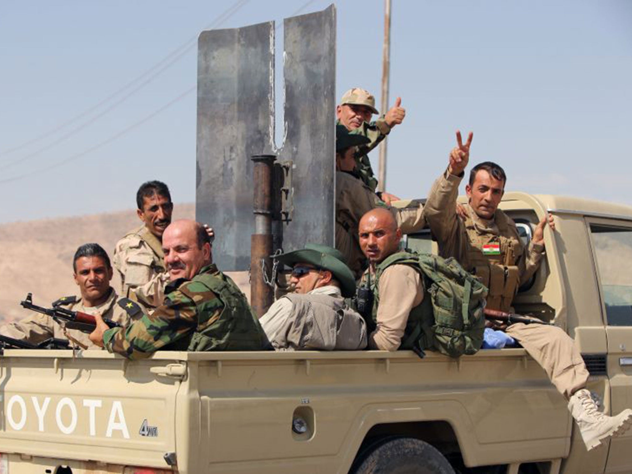 Iraqi Kurdish Peshmerga fighters celebrate recapturing the Mosul dam from Islamic State jihadists