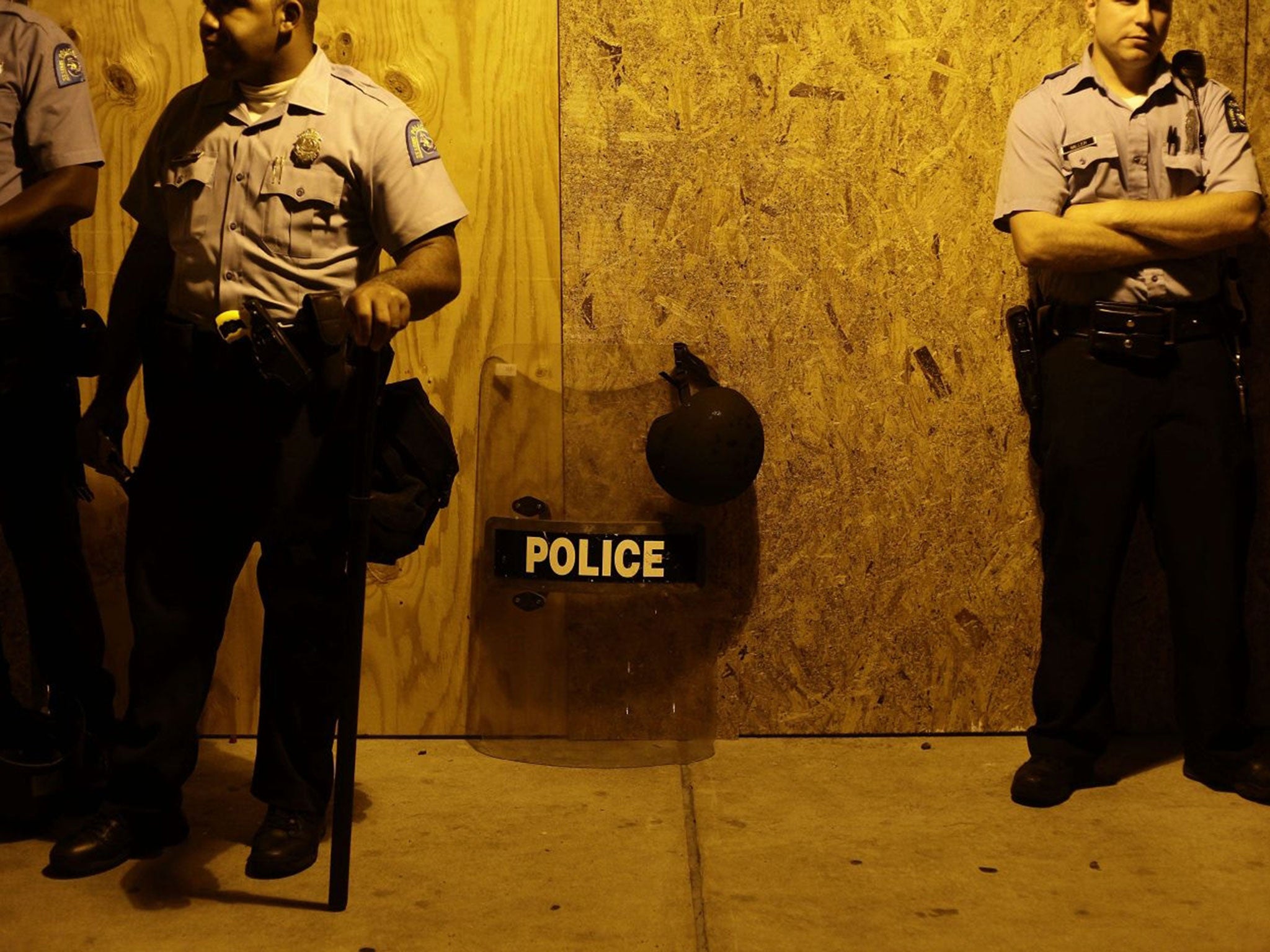 Police officers stand in position as they watch demonstrators protest Michael Brown's murder August 16, 2014 in Ferguson, Missouri.