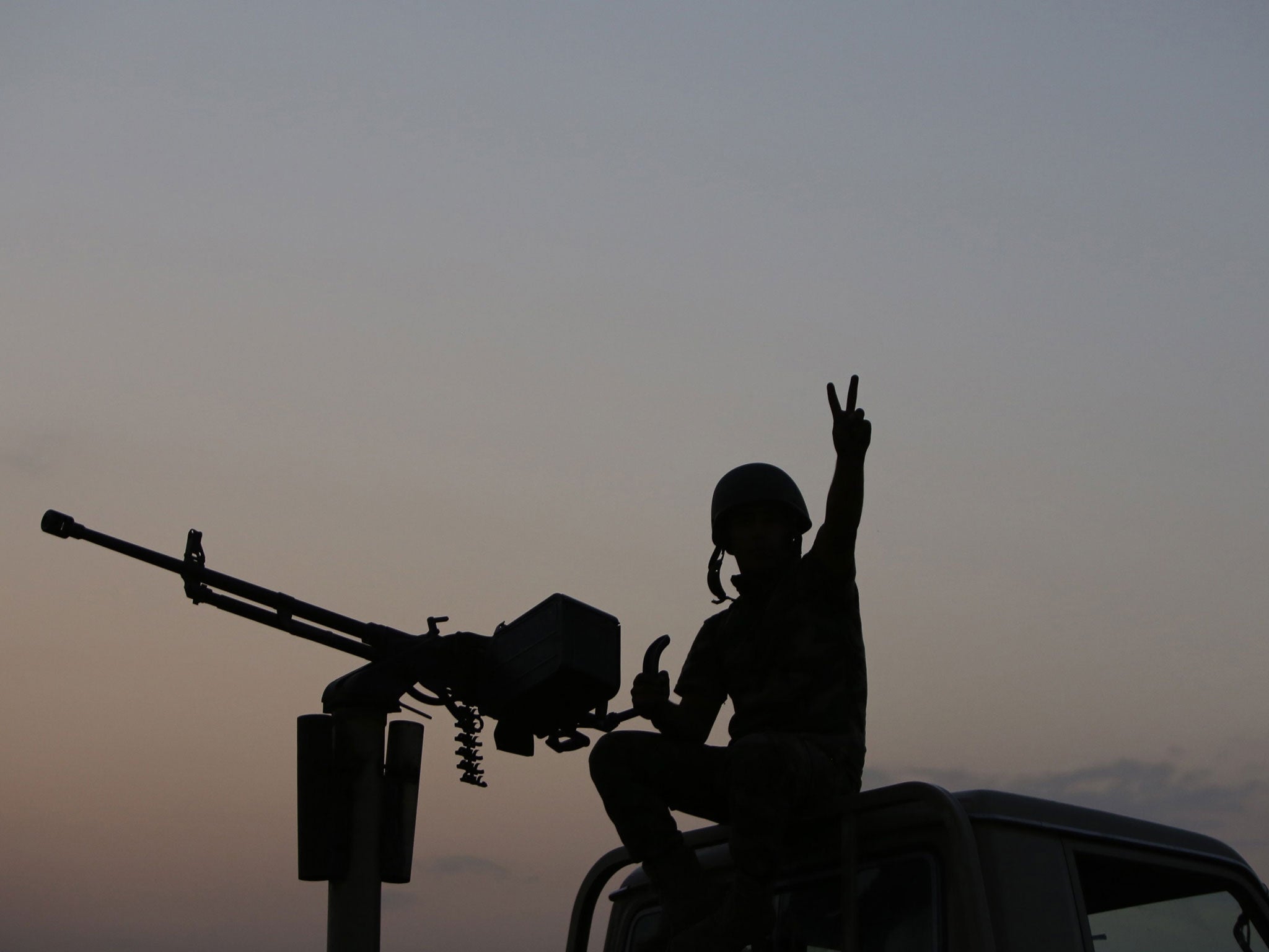 A Peshmerga fighter flashes a victory sign on the front line of fighting with Isis militants east of Mosul