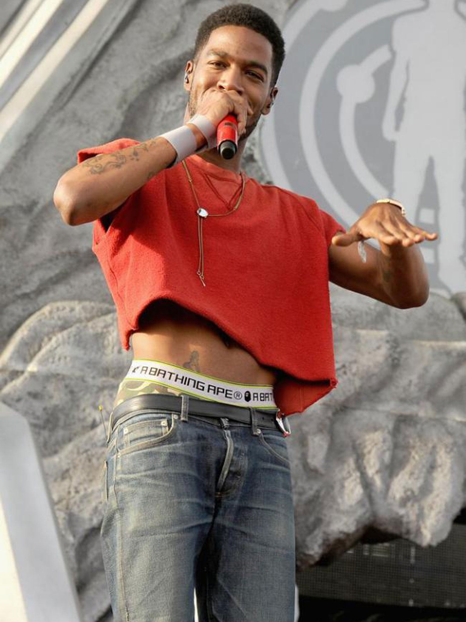 Rapper Kid Cudi performing at Coachella in a bright red crop top