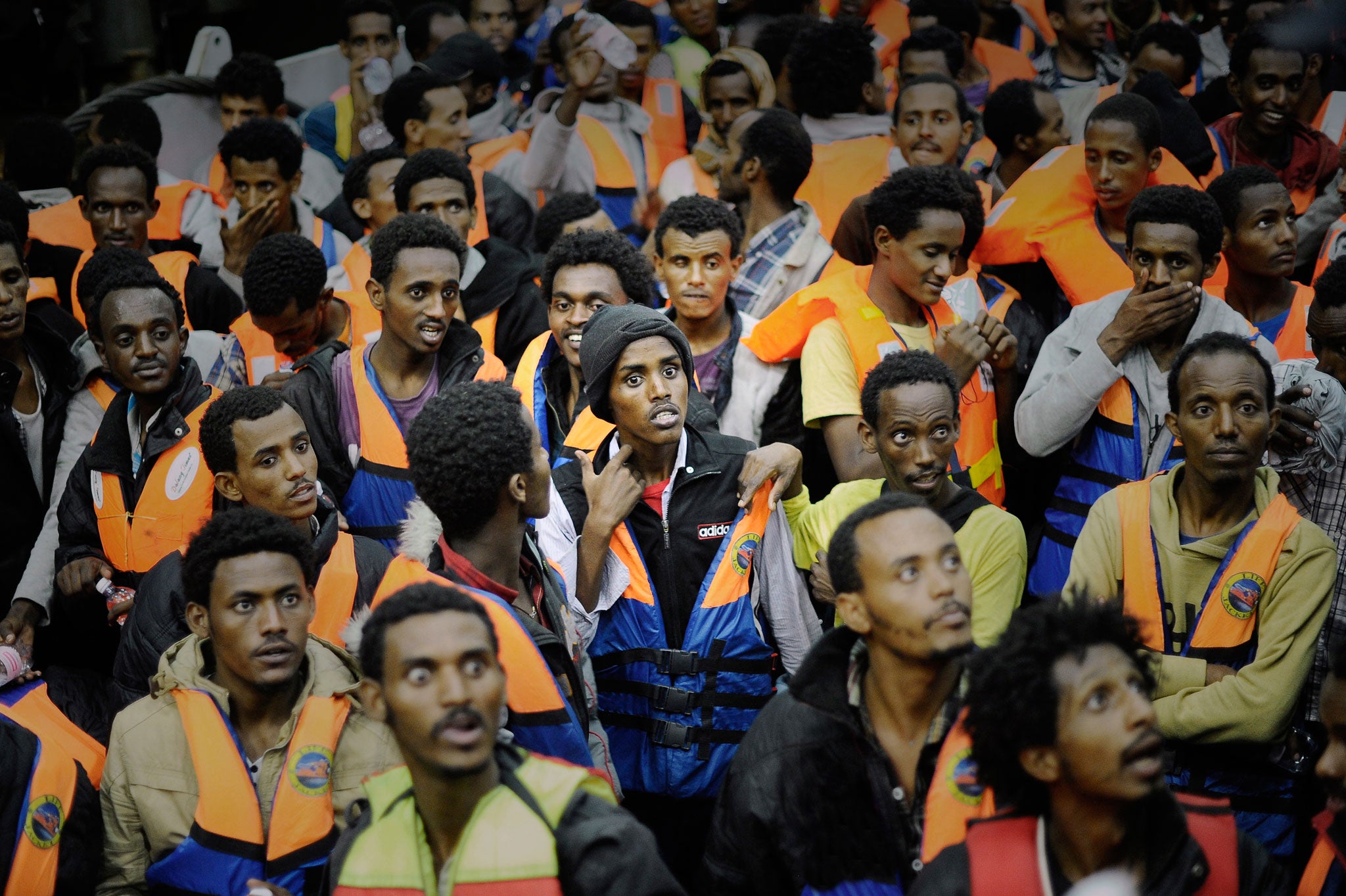 Migrants are pictured on an Italian navy ship after being rescued in open international waters in the Mediterranean Sea between the Italian and the Libyan coasts