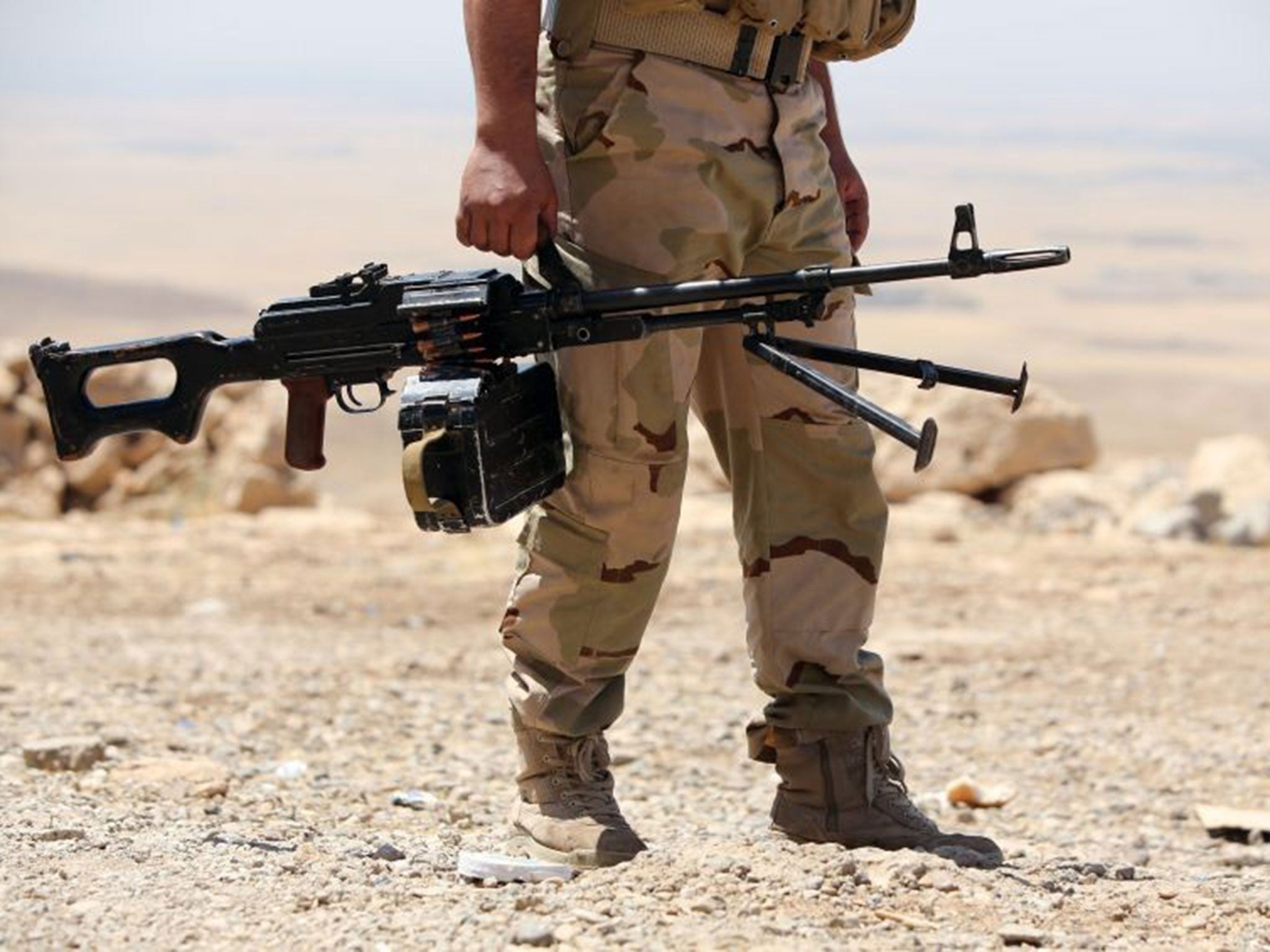 An Iraqi Kurdish Peshmerga fighter taking position on the front line in Bashiqa, north-east of Mosul.