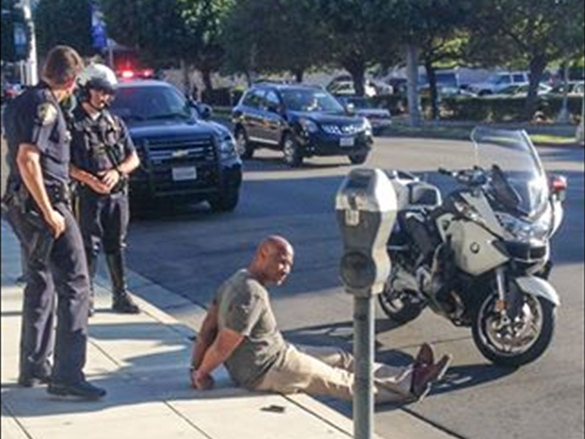 A photo of Charles Belk being detained by police on Friday 22 August