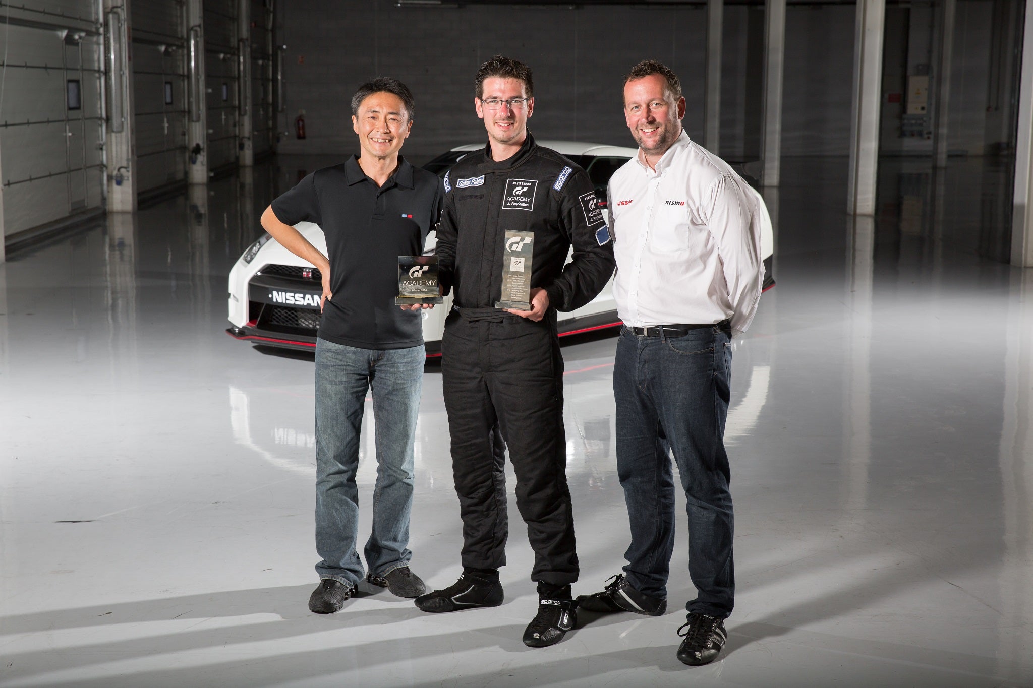 Gran Turismo creator Kazunori Yamauchi and president of NISMO Darren Cox congratulate 2014 European GT Academy winner Gaëtan Paletou