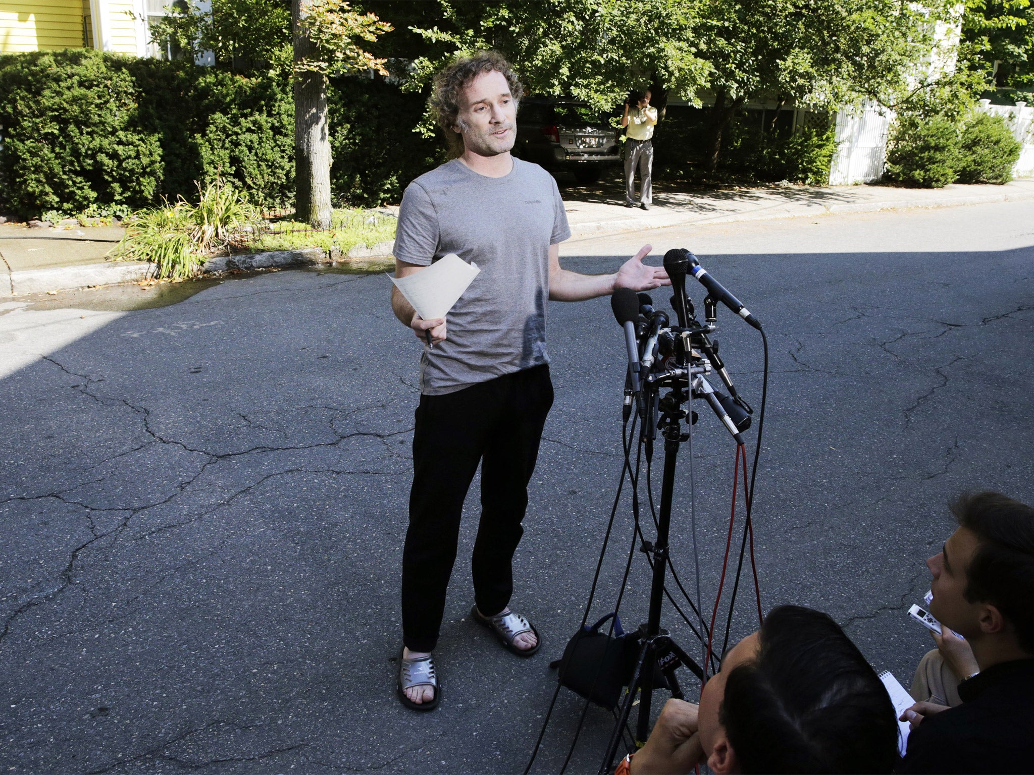 Peter Theo Curtis reads a statement to reporters outside his mother’s home in Cambridge, Mass