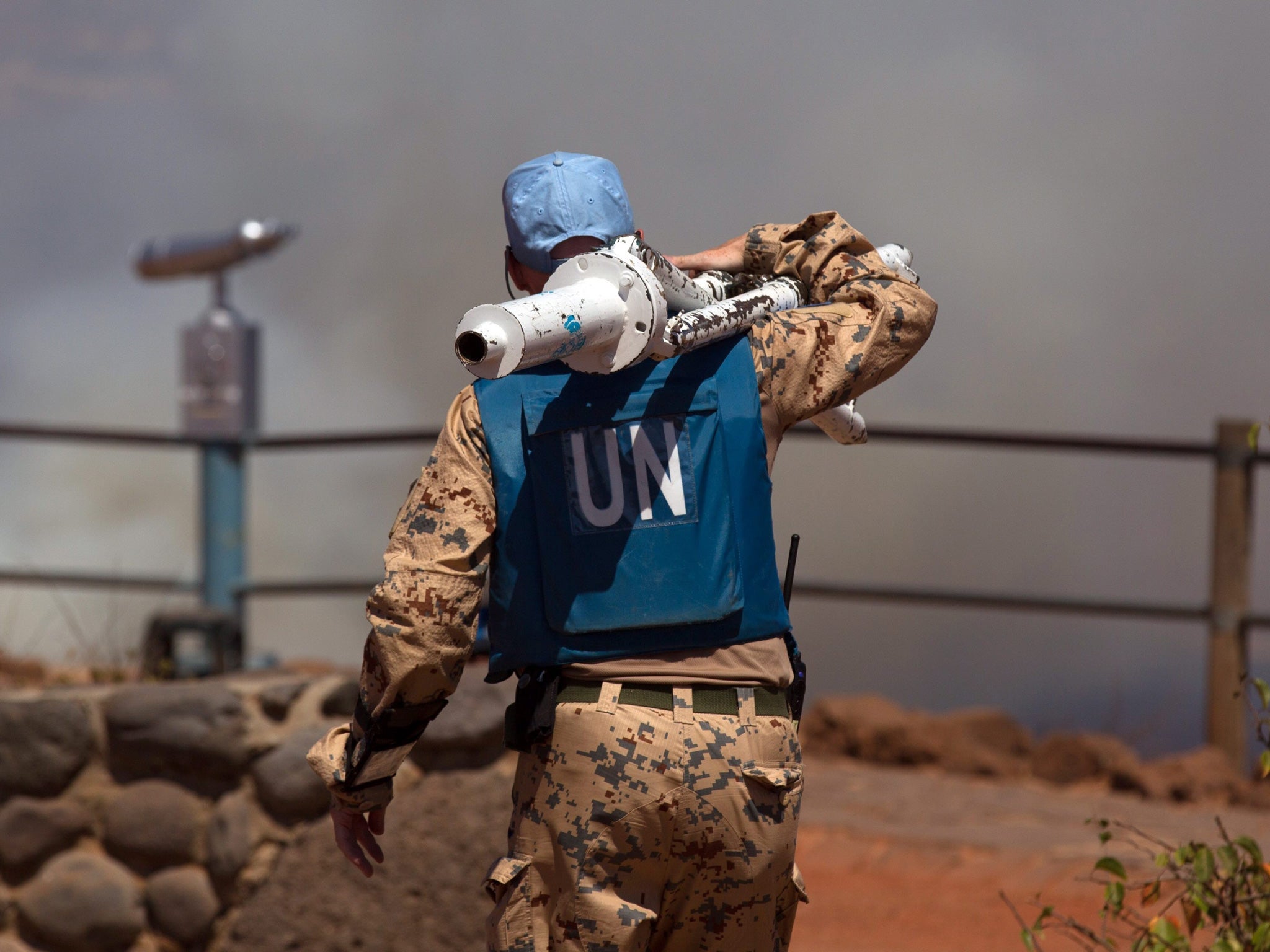 A file photo dated 27 August 2014 of a UN peacekeeper carrying equipments at the Syrian-Israeli border in the Golan Heights