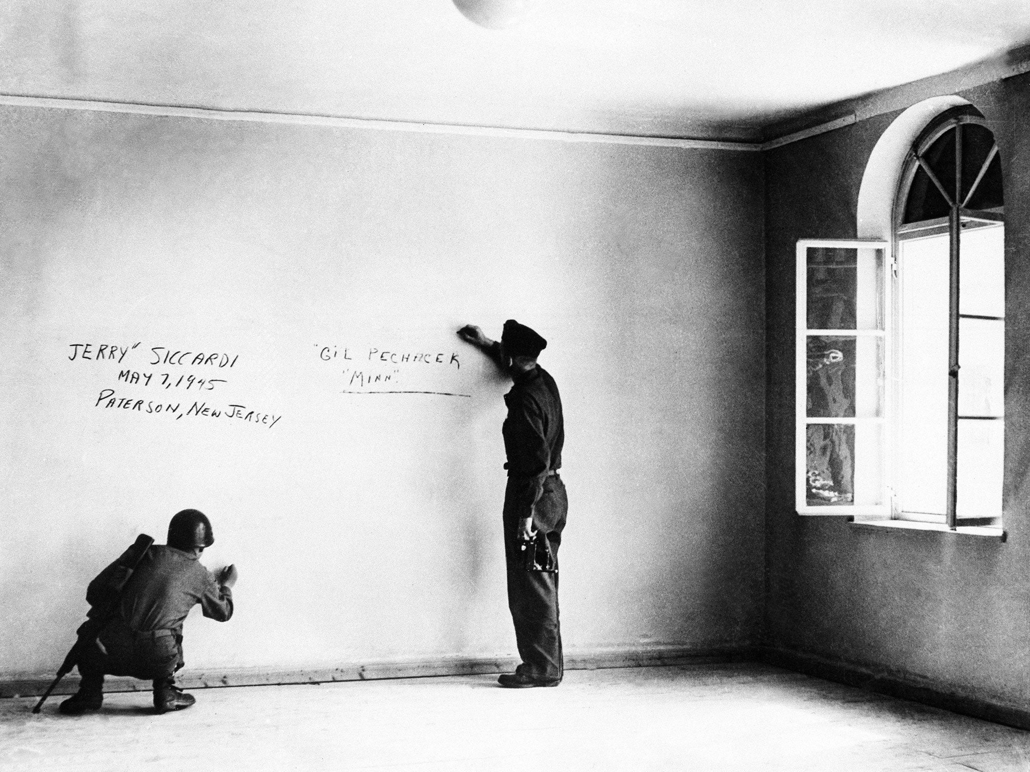 US soldiers write their names on Hitler’s bedroom wall in 1945