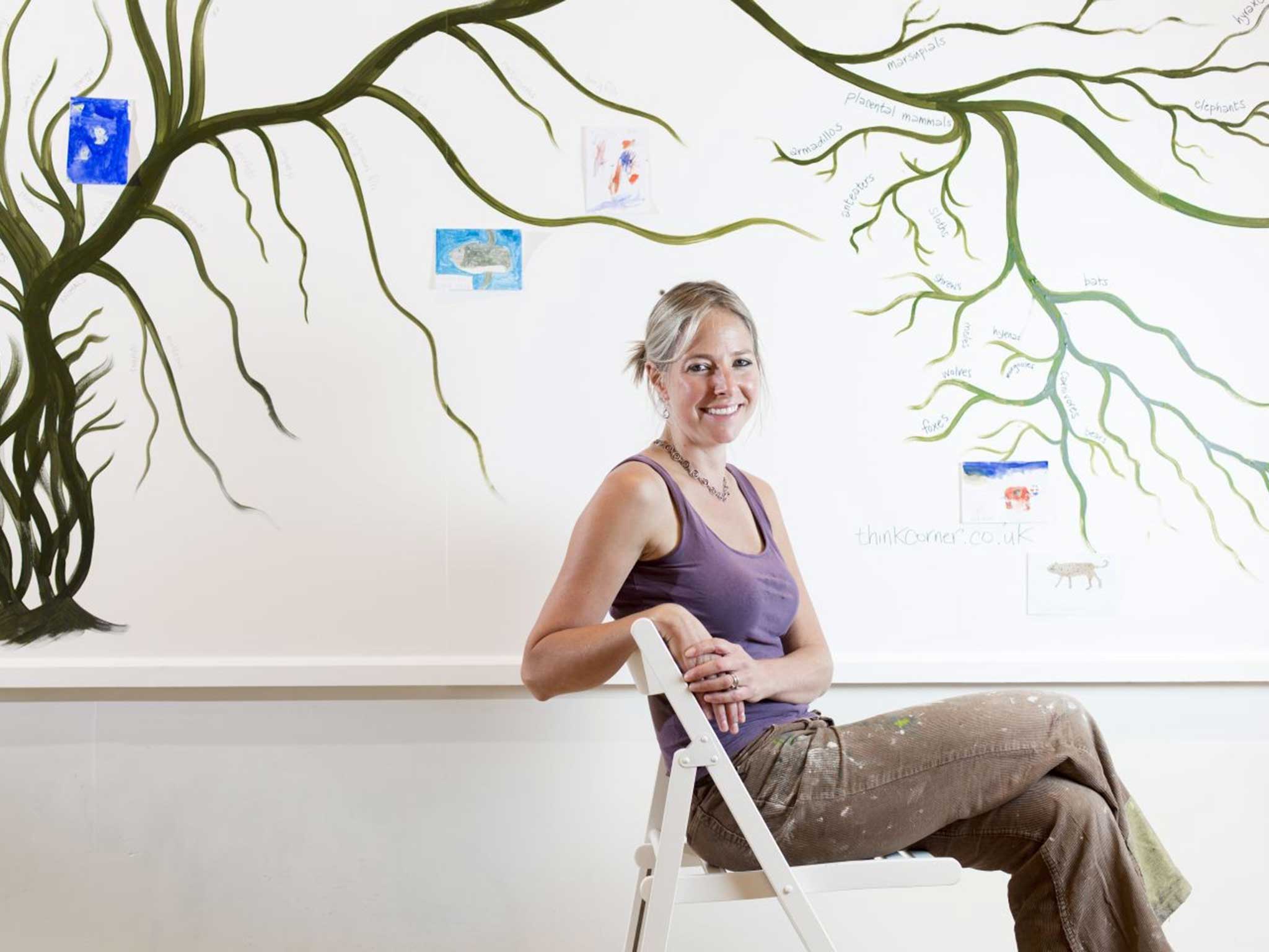 Dr Alice Roberts in front of a "tree of life" she painted at the University of Birmingham's pop up stand at the British Science Festival