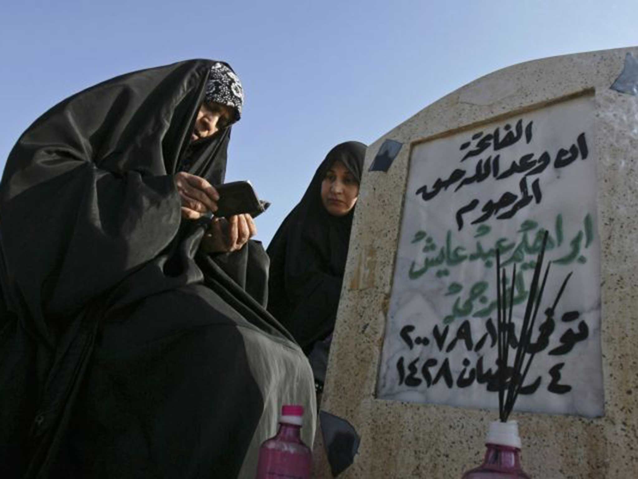 Long wait: Relatives at a victim’s grave