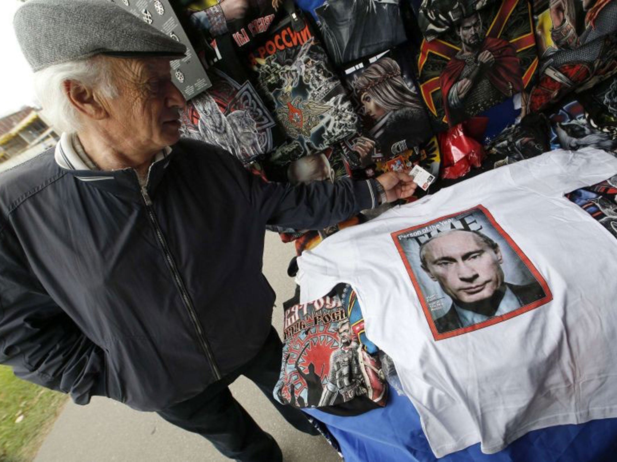 A man looks at the price tag of a T-shirt printed with an image of Russia's President Vladimir Putin