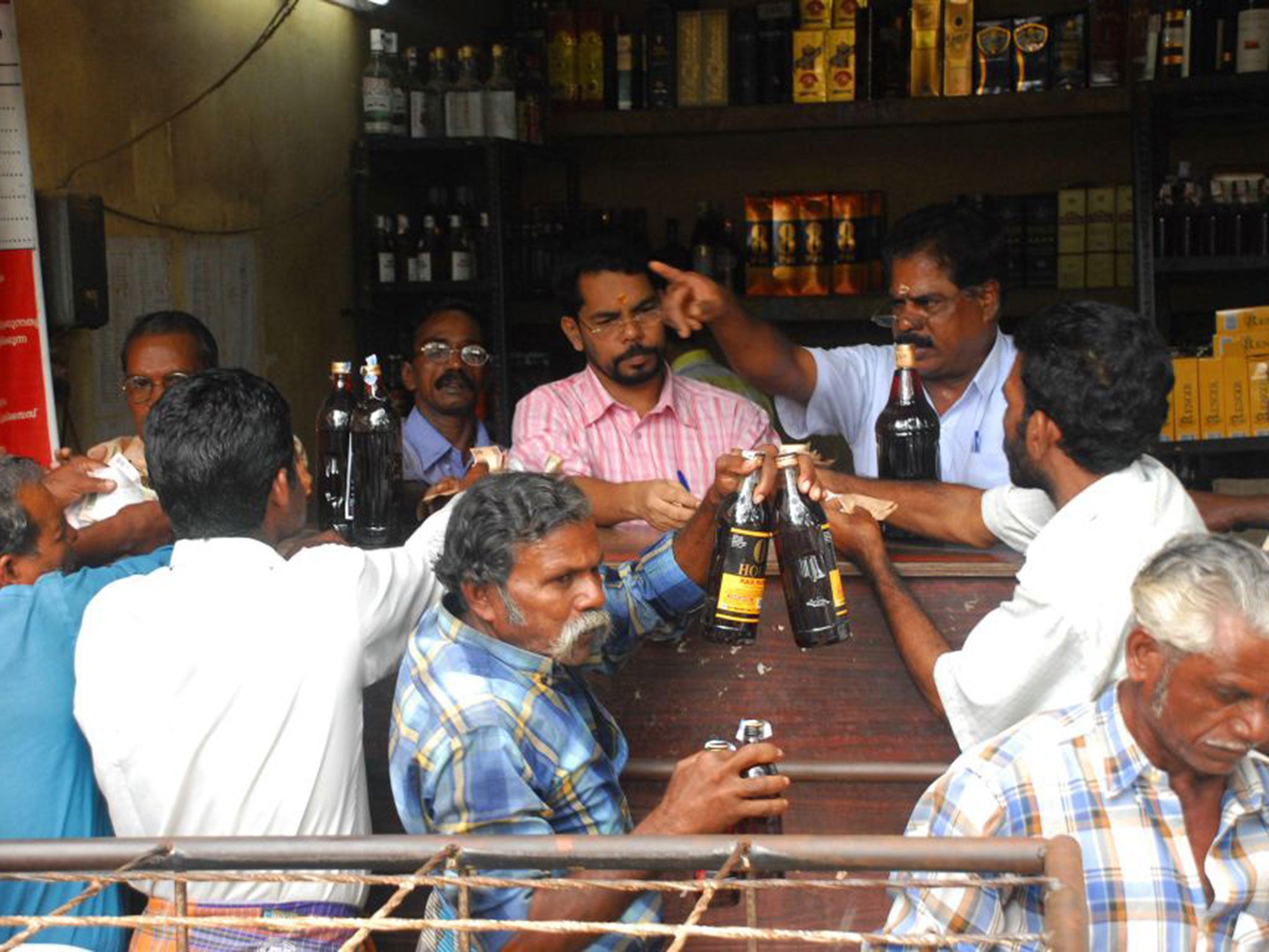 Customers buying liquor from a government shop in Kerala (Getty)