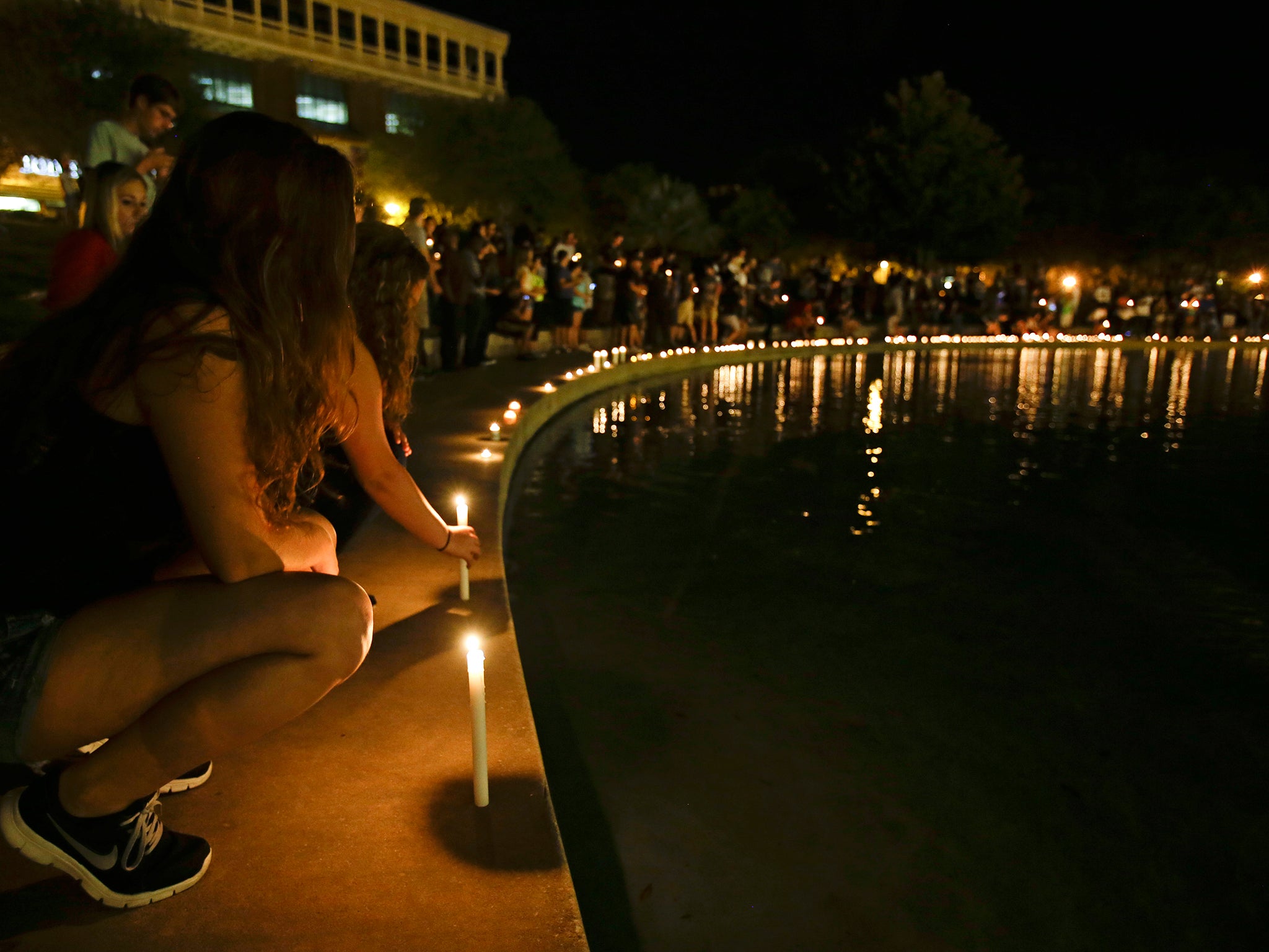 Students and supporters place candles at the edge of a wall surrounding a pond as they take part in a candle light vigil at the University of Central Florida, Wednesday, Sept. 3, 2014, in Orlando, Fla., to honor Steven Sotloff, the second American journal