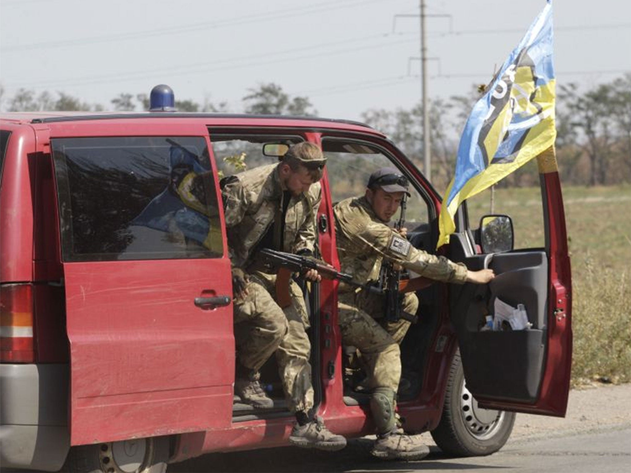 Soldiers of Ukrainian self-defence battalion "Azov" get out of a car as they arrive at a checkpoint in the southern coastal town of Mariupol