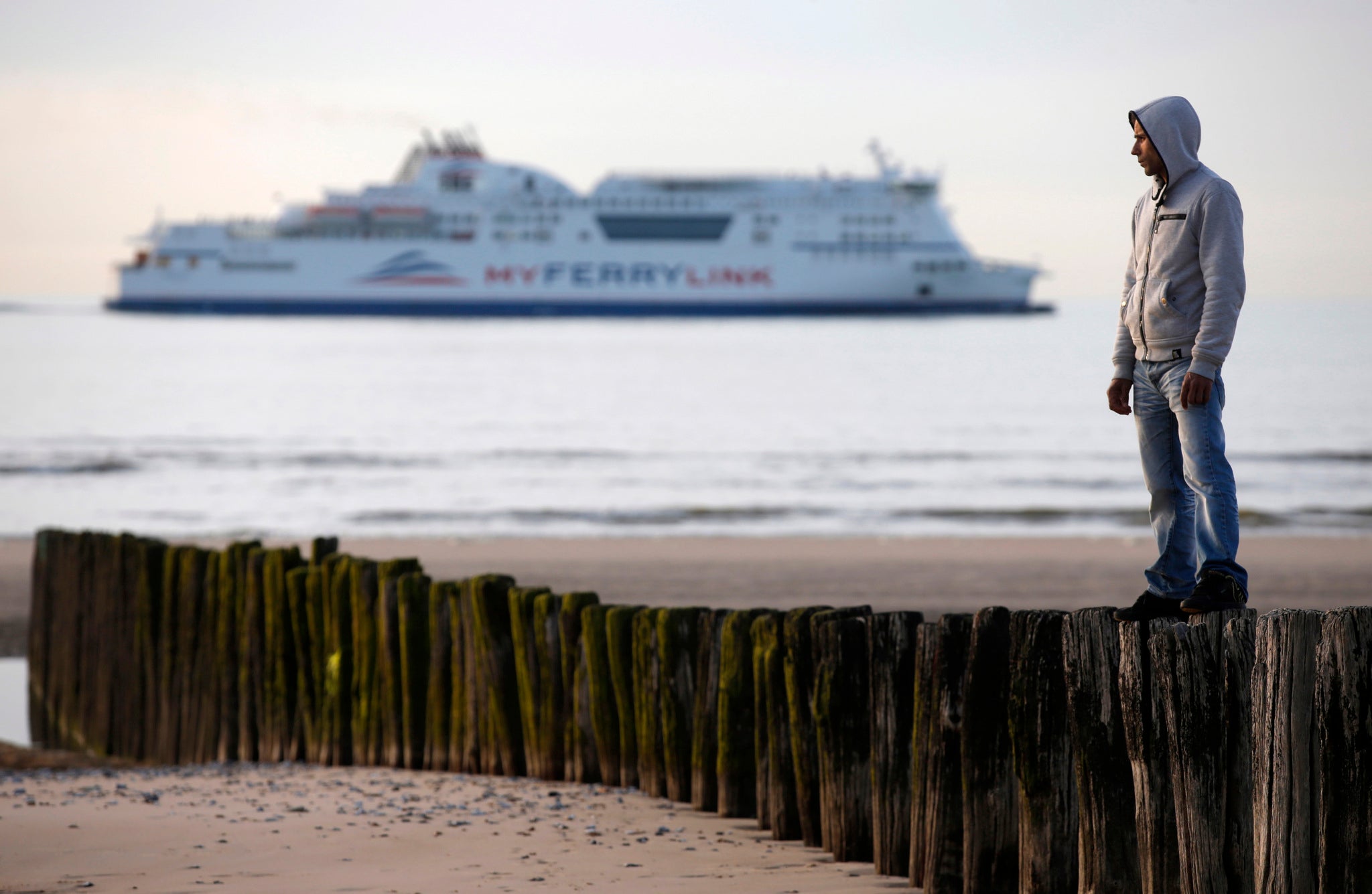 An Afghan migrant stands in Calais on 4 May 2014, as a former British Home Secretary says France should "get their act together"