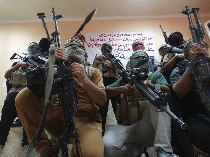 Tribal fighters carrying their weapons pose for photographs during an intensive security deployment to fight against militants of the Islamic State