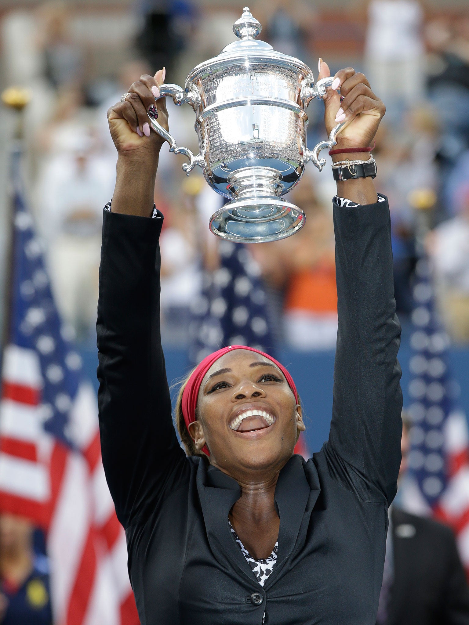 Serena Williams holds up the championship trophy after defeating Caroline Wozniacki, of Denmark, during the championship match of the 2014 U.S. Open