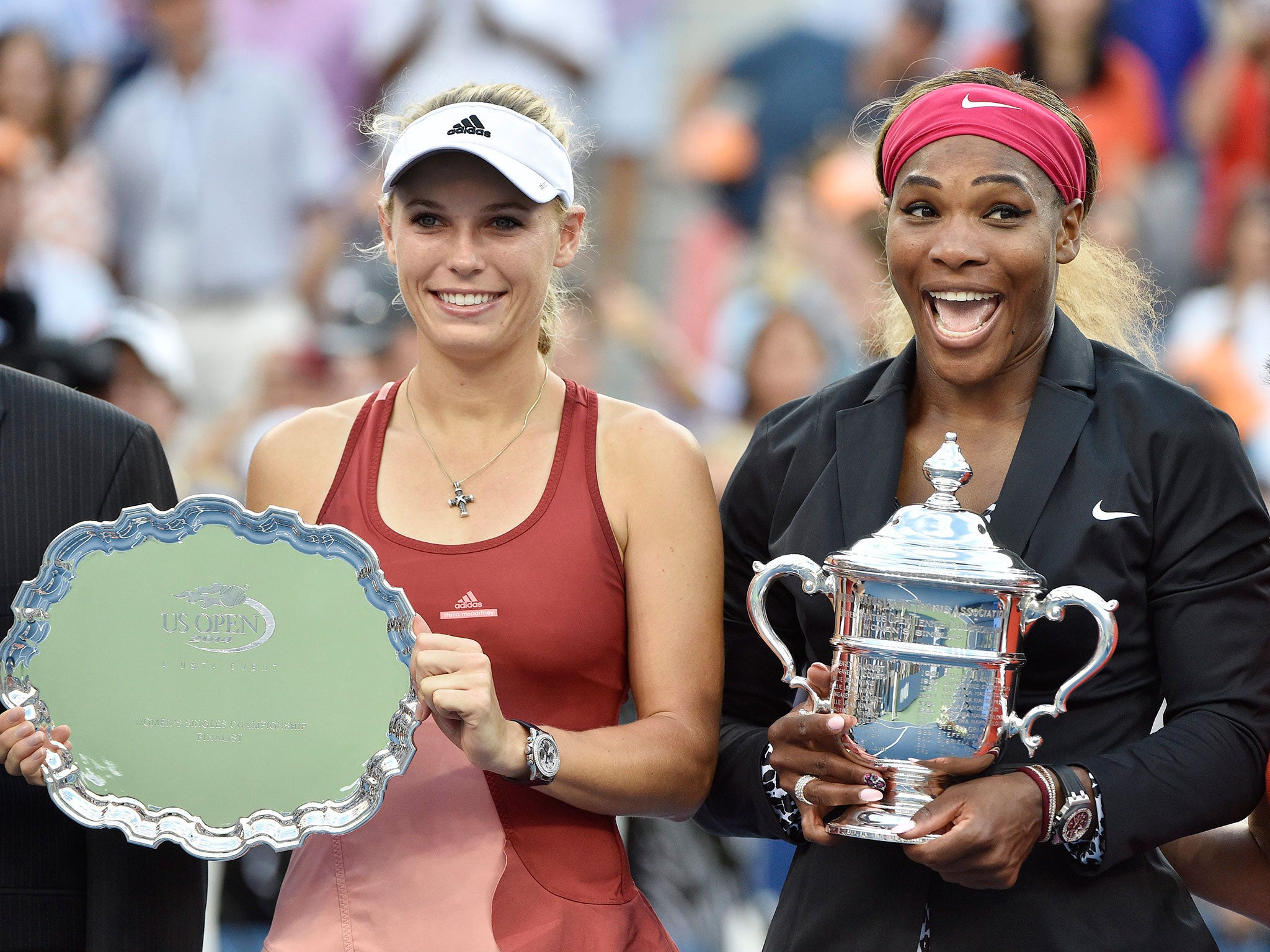 Serena Williams of the US, right, poses with the championship trophy after defeating Caroline Wozniacki of Denmark, left, to win the women's final match of the 2014 US Open Tennis Championship