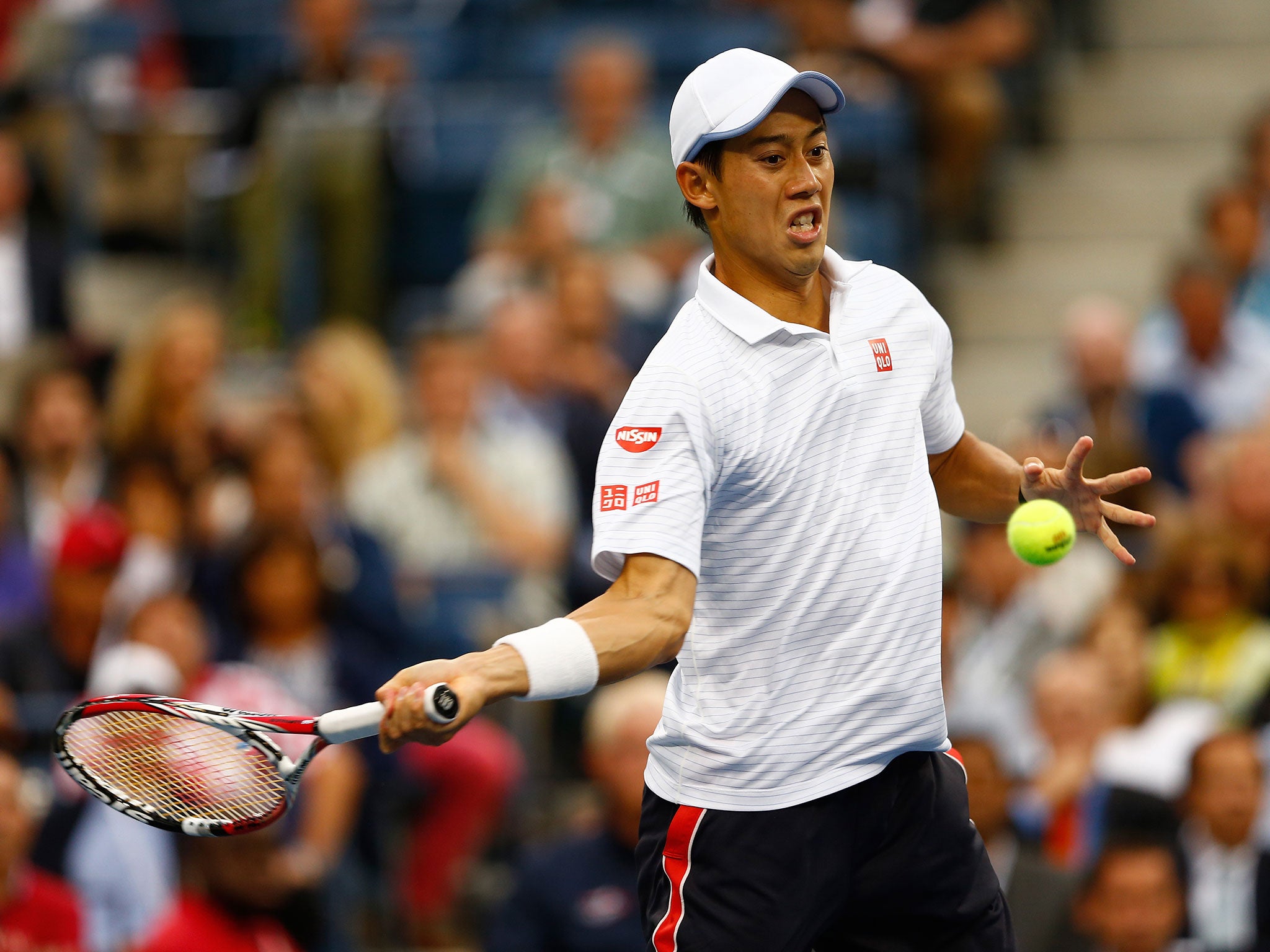 Kei Nishikori returns a shot against Marin Cilic