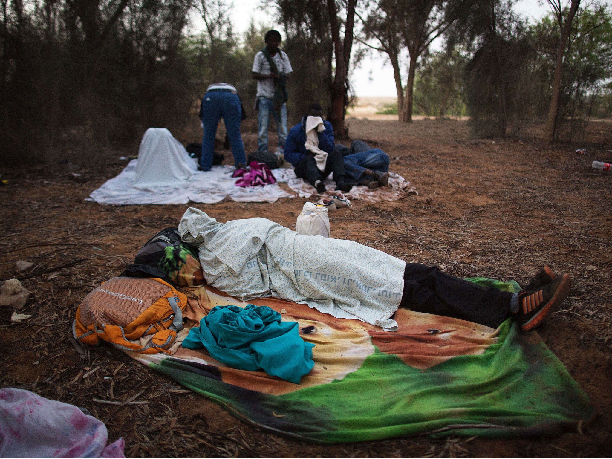 African Asylum seekers covered with blankets near the Nitzana border crossing with Egypt in the Negev Desert. (Menahem Kahana)