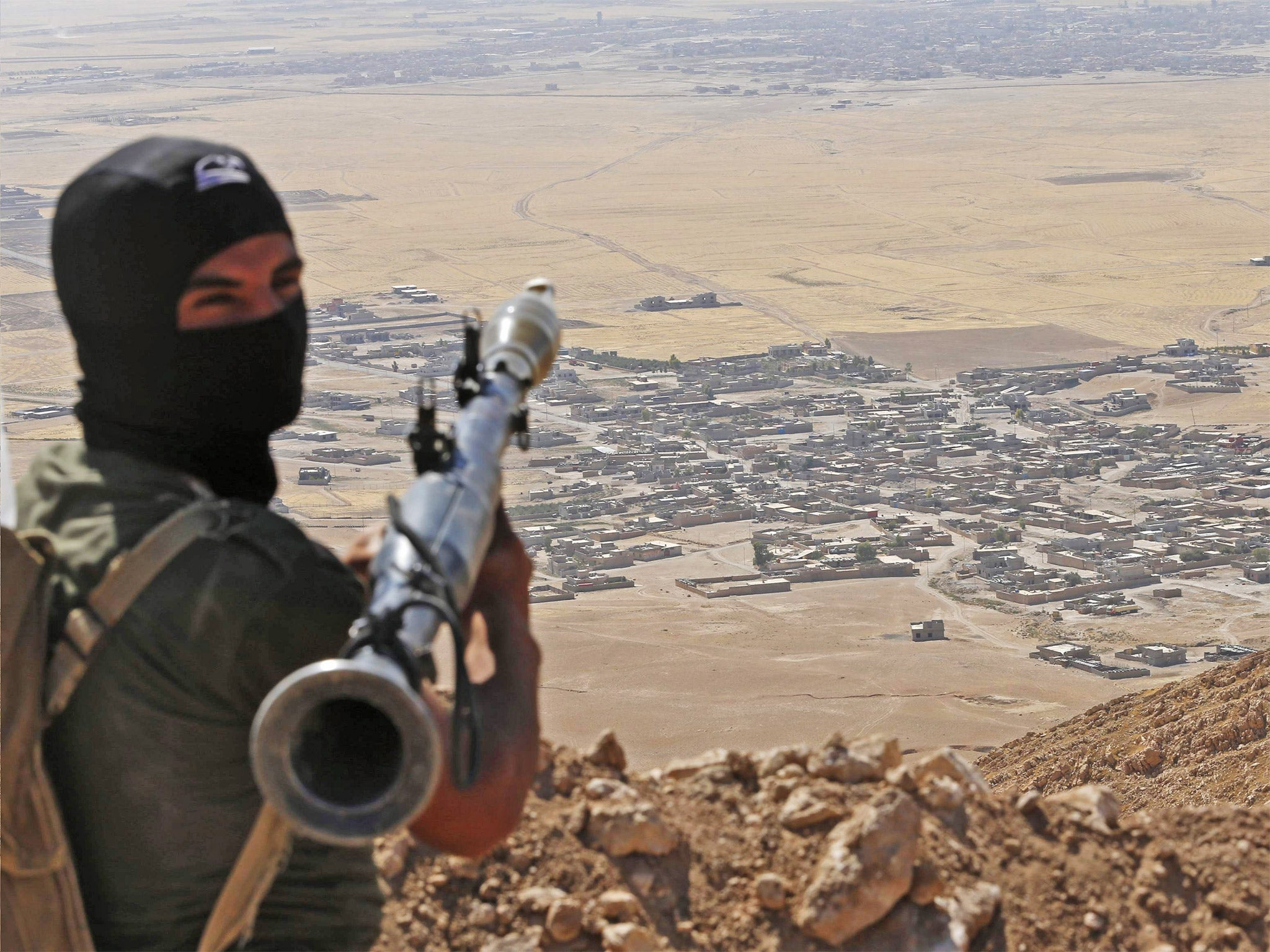 A Kurdish Peshmerga fighter overlooking a village controlled by Isis near Mosul; the Kurds made advances against militants at the weekend