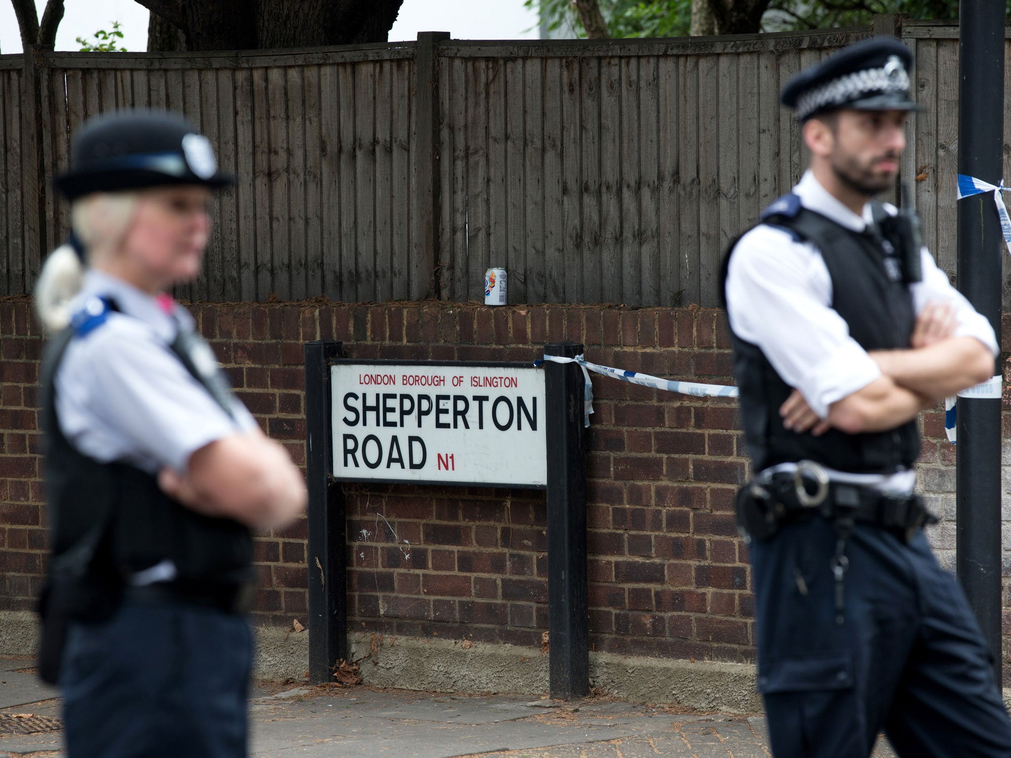 Police officers stand guard at the entrance to Shepperton Road in Islington where police officers shot dead a man who threatened a woman with a knife on September 5, 2014 in London, England.