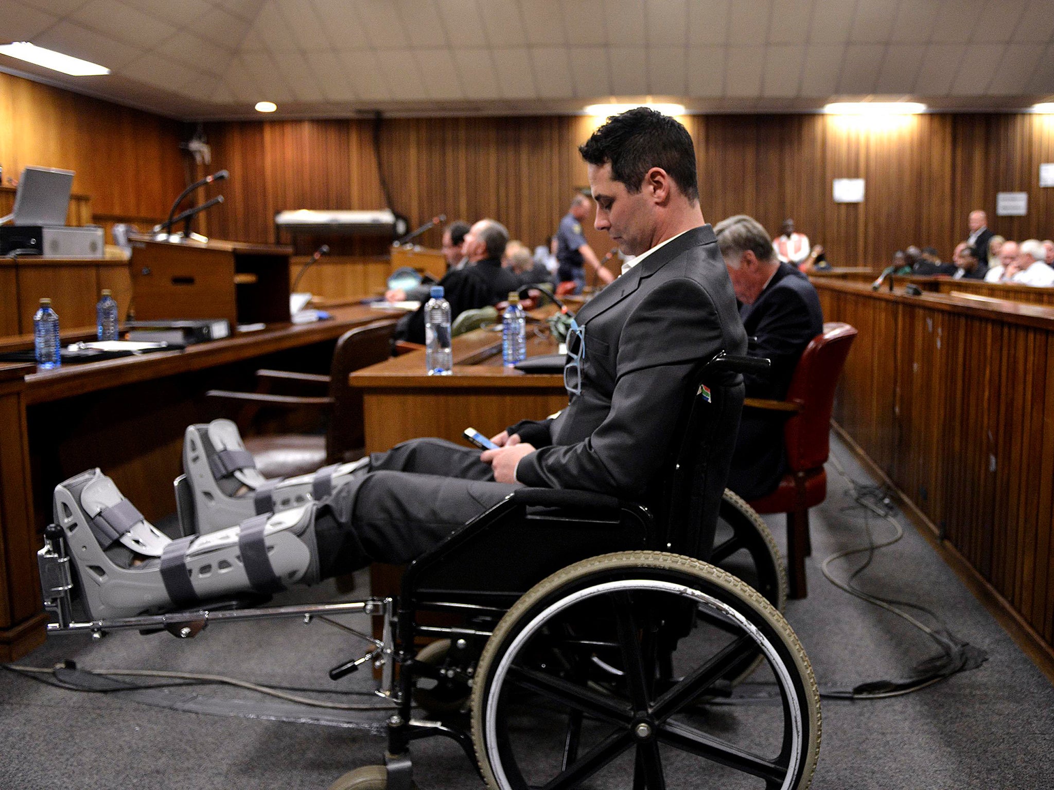 Carl Pistorius, brother of Oscar Pistorius, sits in a wheel chair at the North Gauteng High Court in Pretoria