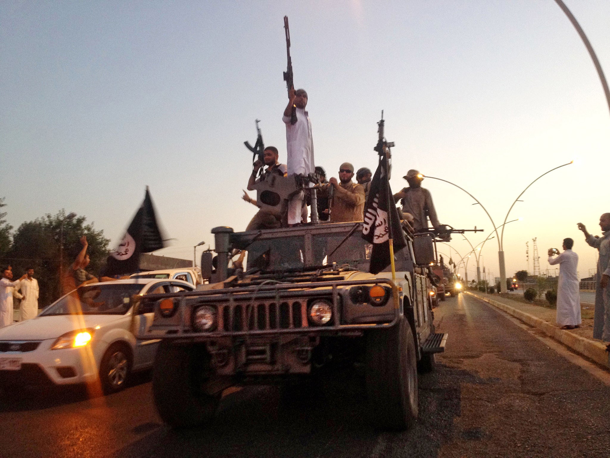 Isis militiamen parade in a captured Iraqi army jeep down
a main road in Mosul, which the US is now targeting