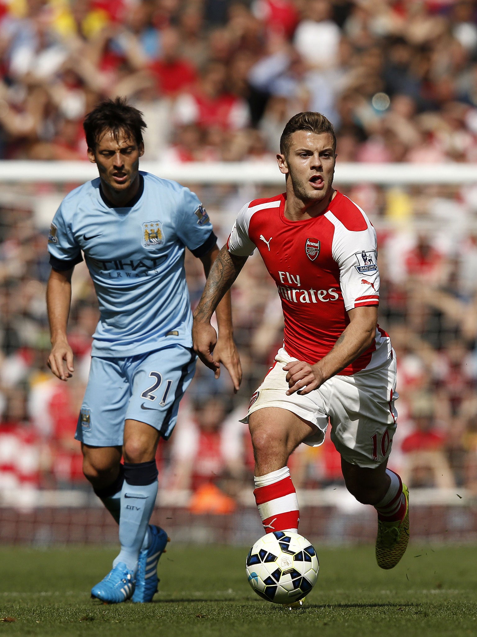 Jack Wilshere, right, makes a break watched by David Silva