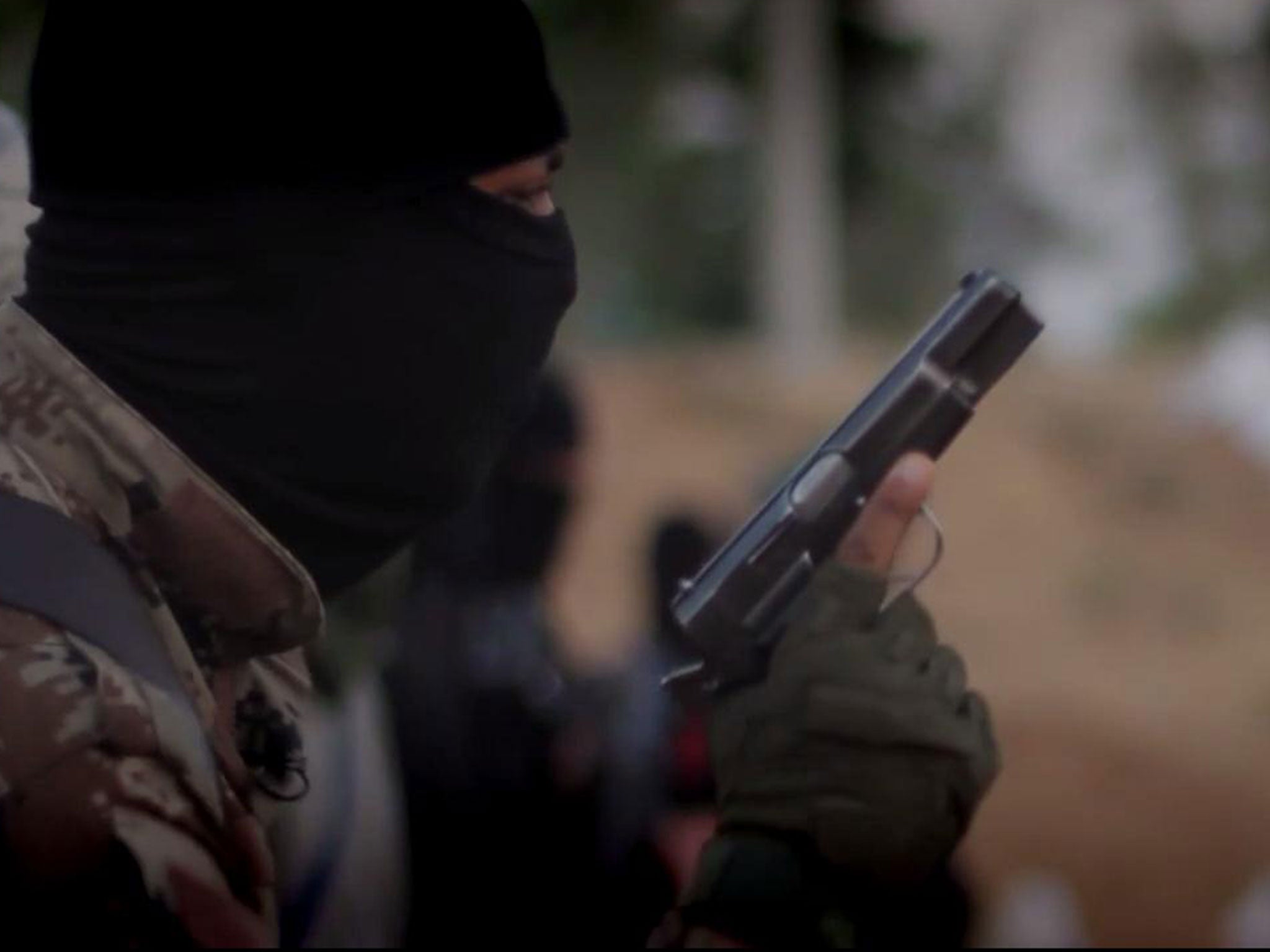 A masked man could be seen holding a gun as men kneeled on the floor