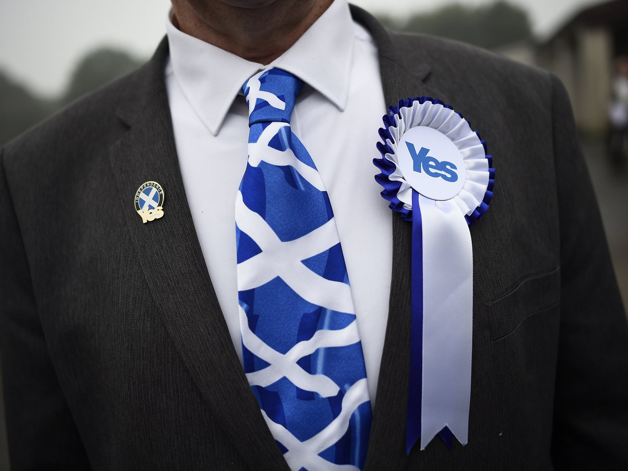 A supporter of the 'Yes' campaign stands outside a polling station