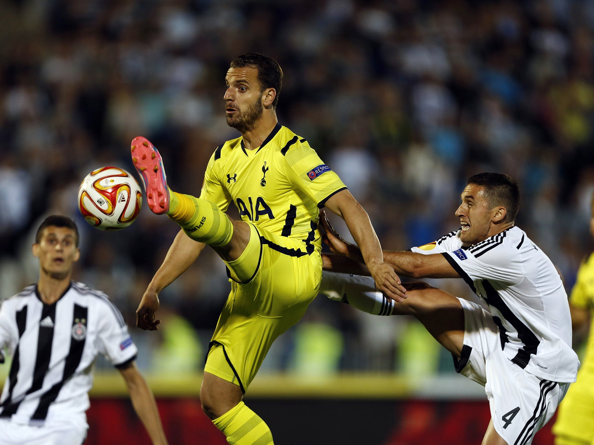 Tottenham Hotspur's Roberto Soldado, center, receives the ball while being guarded by Partizan Belgrade's Miroslav Vulicevic