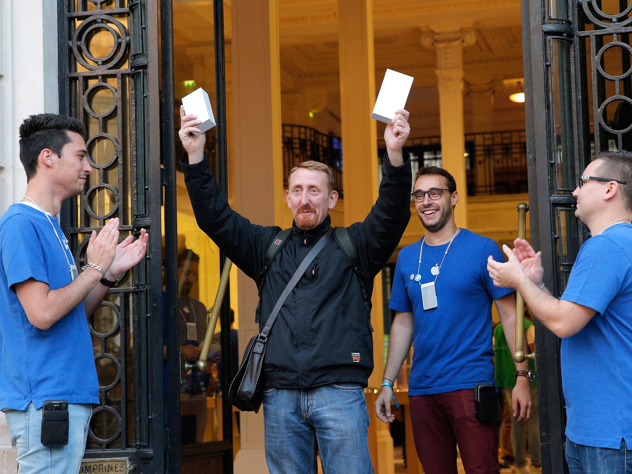 Customer Sylvain leaves an Apple store with boxes as the new iPhone 6 goes on sale in Paris