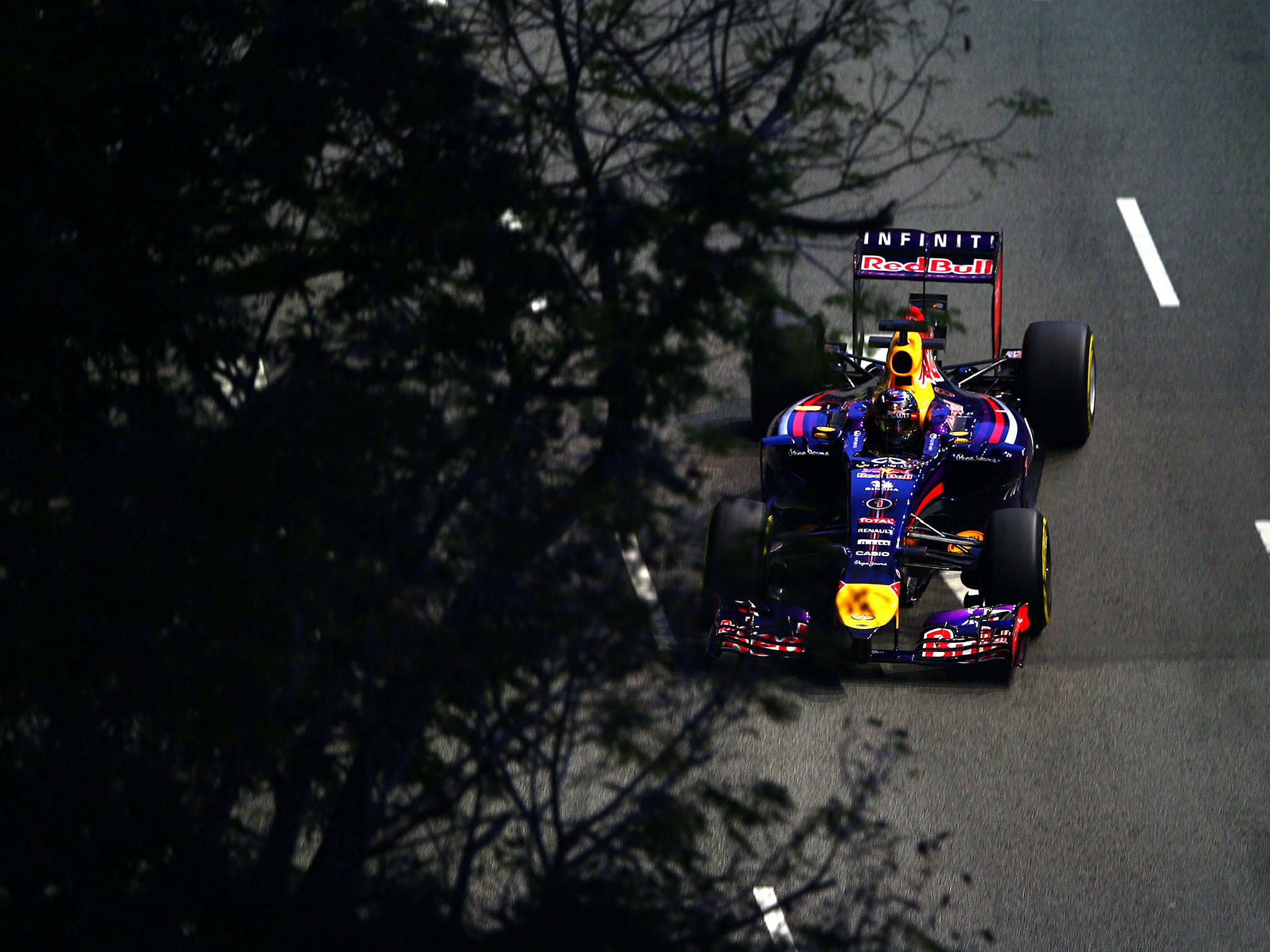 Sebastian Vettel disappears under the trees around the Marina Bay circuit