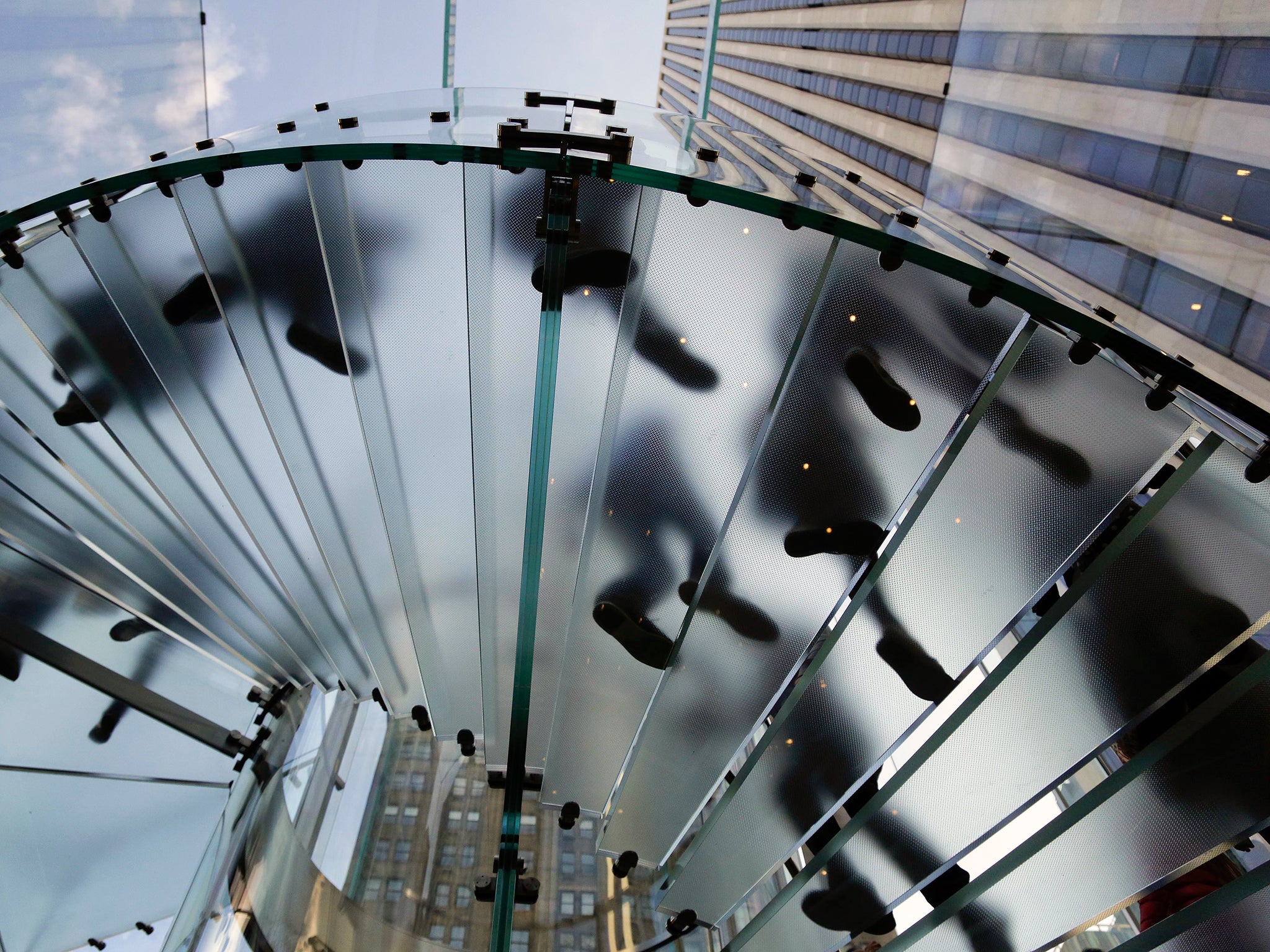 Visitors to the Apple store descend a staircase to the showroom below to purchase the iPhone 6 and 6 Plus in New York (AP)