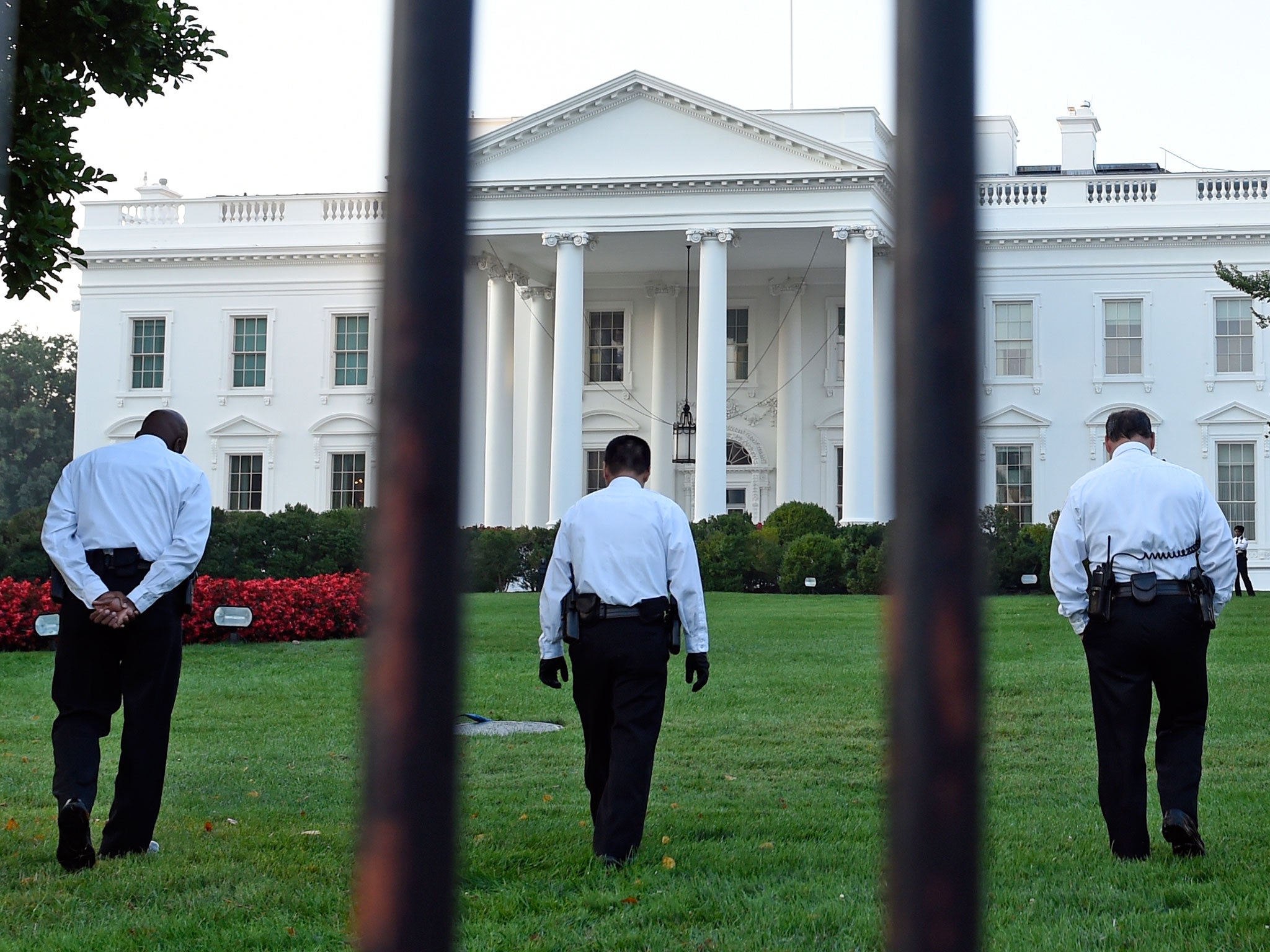 Uniformed Secret Service officers walk along the lawn on the North side of the White House in Washington. The Secret Service is coming under renewed scrutiny after a man scaled the White House fence and made it all the way through the front door before he was apprehended